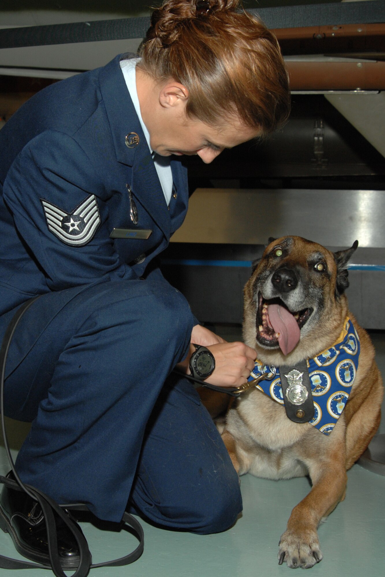 Tech. Sgt. Rebecca Lind, a dog handler with the 1st Special Operations Security Forces Squadron, spends time with Marco, a military working dog with the 1st SOSFS, Aug. 1 at the Air Armament Museum. Marco, who has been at Hurlburt Field since March 2005, was retired and adopted by Sergeant Lind. (U.S. Air Force photo/Senior Airman Stephanie Jacobs)