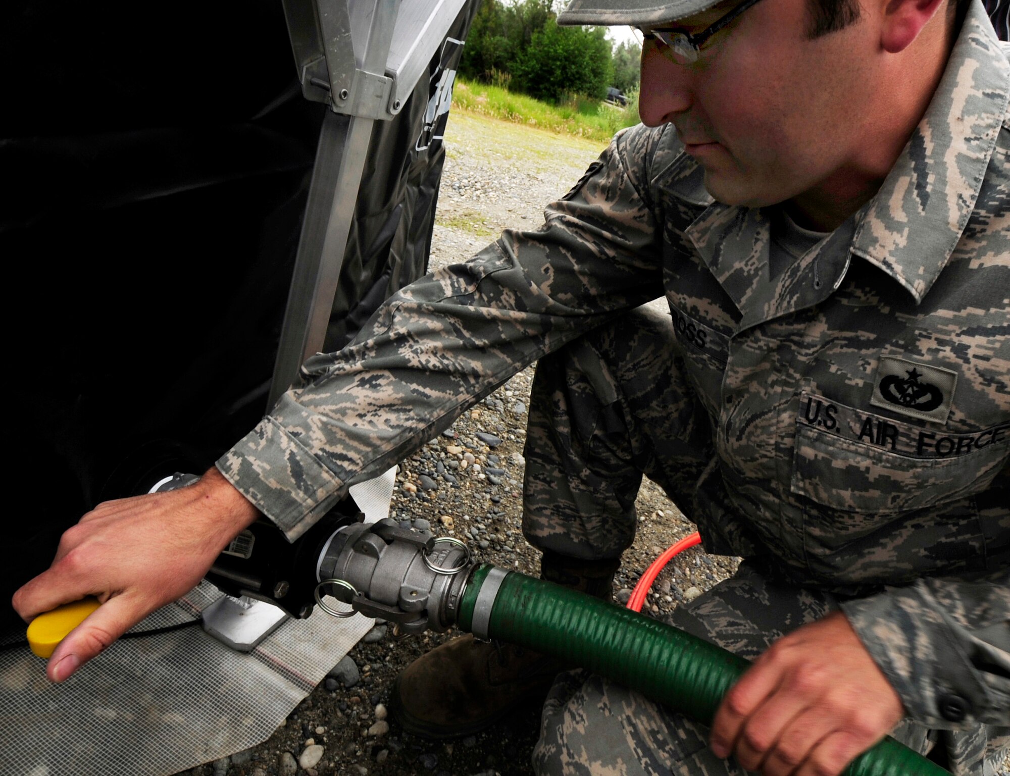 Liquid fuels maintenance craftsman Staff Sgt. Richard Ross connect a discharge hose to the side of a fast tank  in preparation for a oil/light fuels spill water contamination clean-up exercise July 23, 2008 at Eielson Air Force Base, Alaska. The discharge hose is the system in which hazardous substances are removed from a body of water to the fast tank. This exercise is an annual requirement based on the Oil Pollution Act of 1990. (U.S Air Force Photo by Tech. Sgt. Eric T. Sheler)