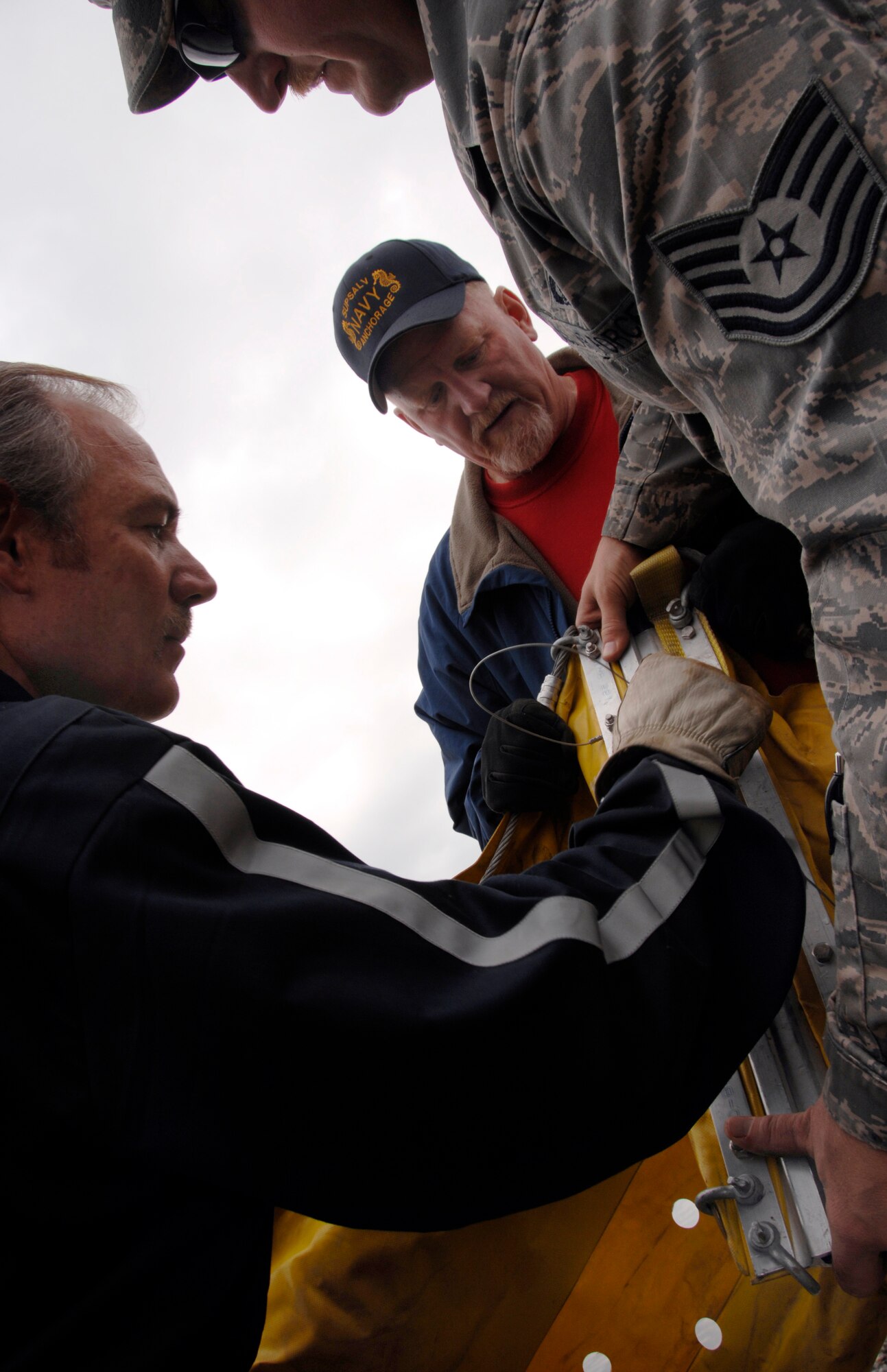 Mr. Randy Smith (left), the 354th Civil Engineer Hazmat superintendent, Mr. Dale Colby (center), a U.S Navy Supervisor of Salvage contractor, and Tech. Sgt.  Curtis Kastner, the NCOIC of Liquid Fuels Maintenance connect to parts of a contamination boom in preparation for a oil and light fuels spill water contamination clean-up exercise July 23, 2008 at Eielson Air Force Base, Alaska.  This exercise is an annual requirement based on the Oil Pollution Act of 1990. (U.S Air Force Photo by Tech. Sgt. Eric T. Sheler)