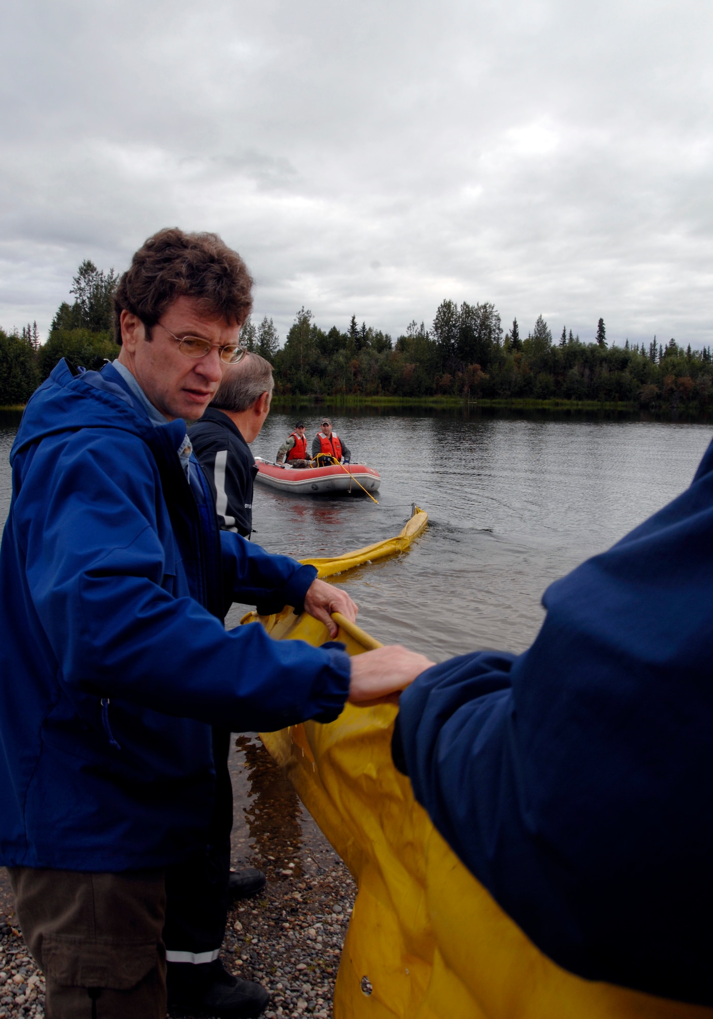 Tom Rayburn, an oil and fuel spill clean up instructor from the Defense Energy Support Center assists placing a water contamination  boom into Bear Lake for a oil and light fuels spill water contamination clean-up exercise  July 23, 2008 at Eielson Air Force Base, Alaska .  A contamination boom provides a barrier between contaimated water and uncontaiminated water.  This exercise is an annual requirement based on the Oil Pollution Act of 1990. (U.S Air Force Photo by Tech. Sgt. Eric T. Sheler)