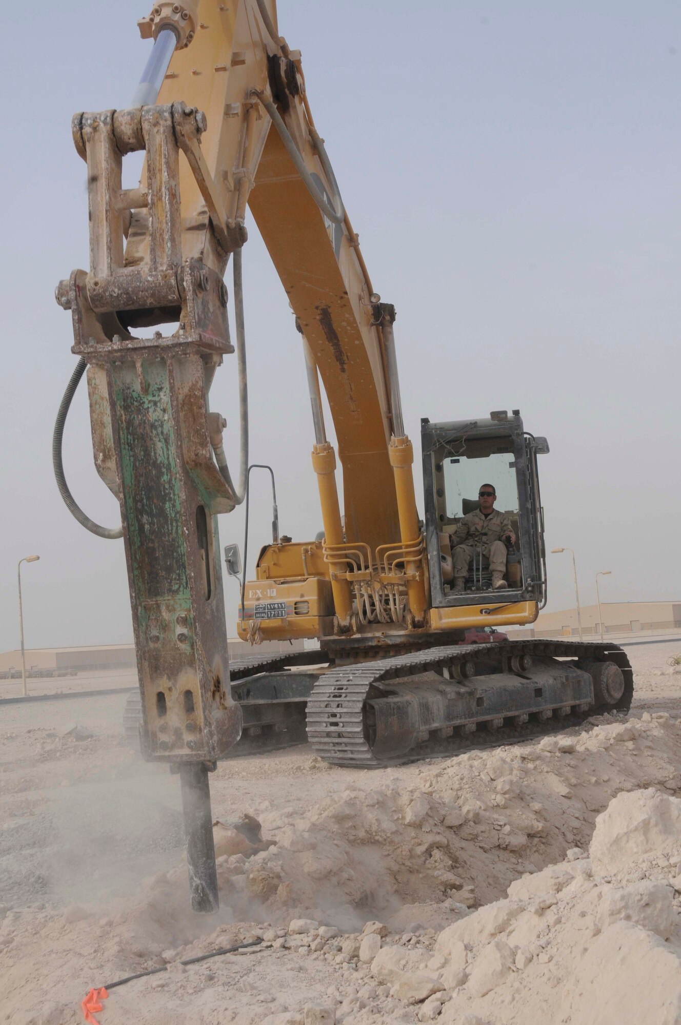 Staff Sgt. David Dengate, a pavement and construction equipment operator with the 379th Expeditionary Civil Engineer Squadron, uses an excavator with a hydro hammer attachment to loosen the ground so it can be dug out Aug. 4, 2008, at an undisclosed location in Southwest Asia. Sergeant Dengate, a native of Detroit, Mich., is deployed from McConnell Air Force Base, Kan. (U.S. Air Force photo by Staff Sgt. Darnell T. Cannady/RELEASED)