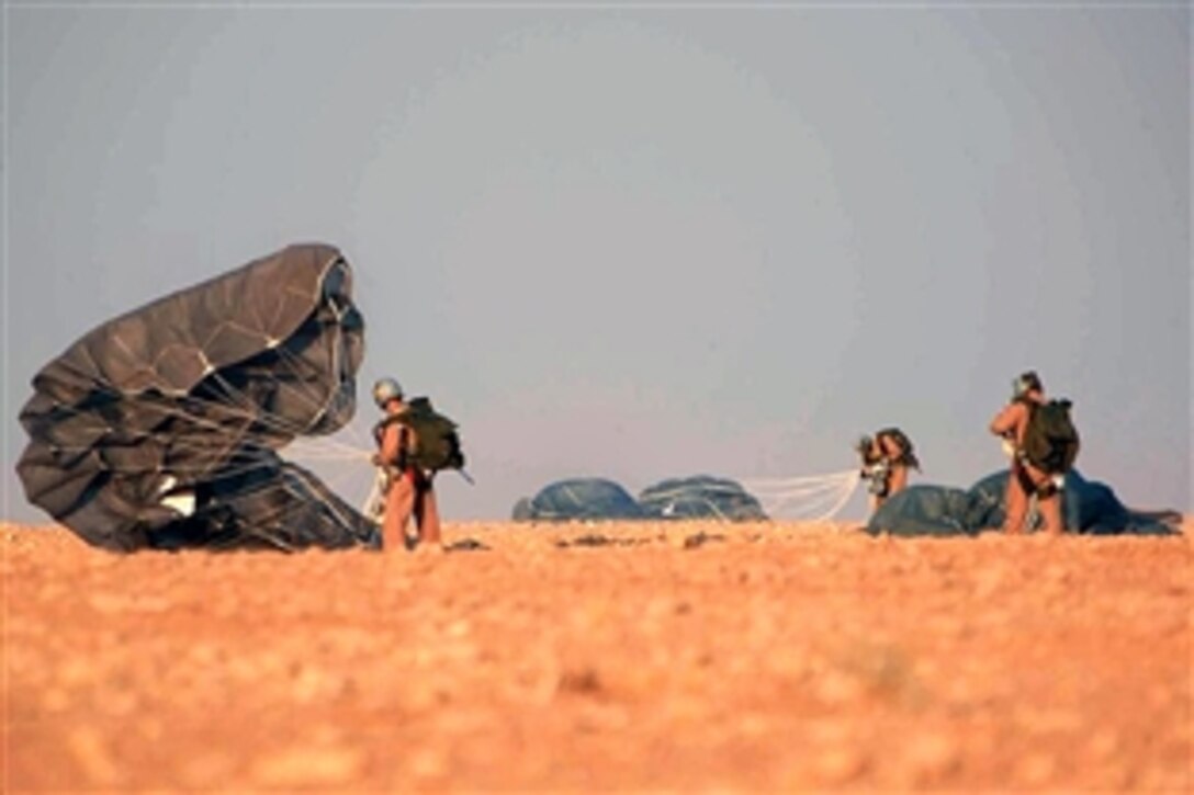 U.S. Marine Corps Gunnery Sgt. Marc Hogue, Sgt. Matt Jonas, and Sgt. David Walther gather their canopies on the outskirts of Al Asad Air Base, Anbar province, Iraq, July 28, 2008. The Marines are assigned to the 3rd Reconaissance Battalion, Multinational Forces West. 
