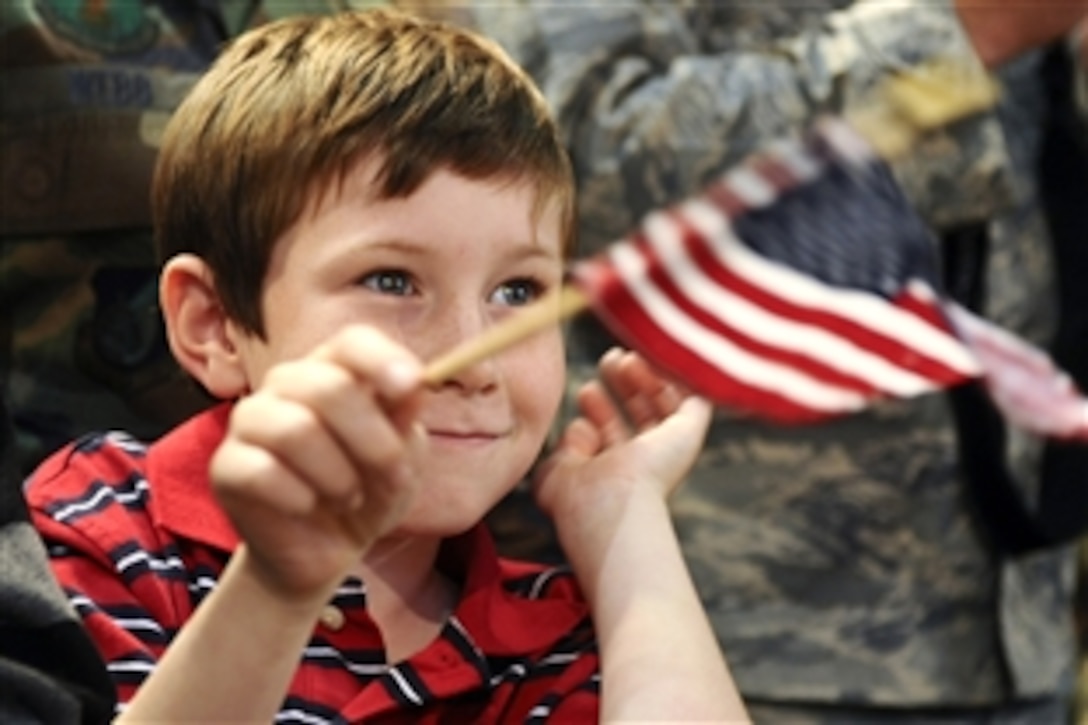 A boy watches President George W. Bush as he makes a speech on Eielson Air Force Base, Alaska, Aug. 4, 2008. Bush stopped on the base before traveling to the 2008 Olympic Games in Beijing, China. During his visit he spoke to more than 2,000 military personnel and thanked individual troops for their service.