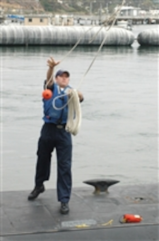 A U.S. Navy sailor aboard the submarine USS Helena (SSN 725) tosses a line to the pier prior to the vessel's homecoming ceremony at Naval Base Point Loma, Calif., on July 30, 2008.  The Helena returned to San Diego, Calif., after completing a six-month deployment in the Western Pacific Ocean.  