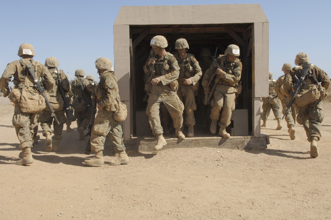 Company I recruits rush out of a mock light armored vehicle to start the course. Their drill instructors challenged both squads to race to the other side of the course.