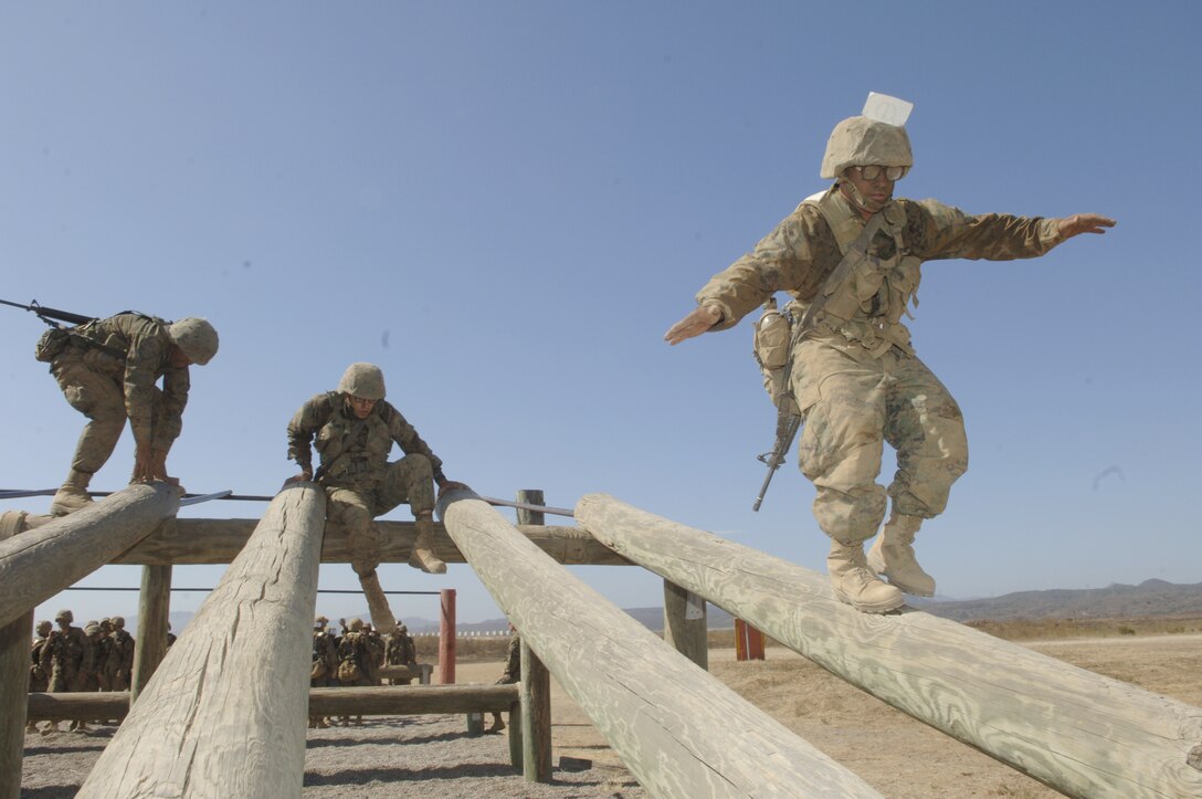 Recruit Christopher M. Duncan, Platoon 3209, balances himself as he walks down a log obstacle.