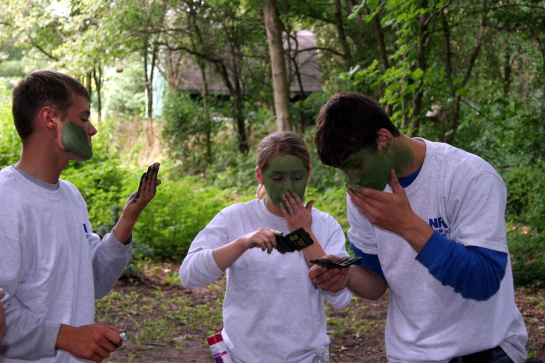 Poolees from Recruiting Substation Janesville, Recruiting Station Milwaukee, apply camouflage paint to their faces after receiving a "Cover and Concealment" class from Marines from Fox Company, 24th Marines.  This class was part of the daily activities following a live fire rifle range with the AR-15 at Stone Bank Sportsman's Club in Oconomowoc, Wis., August 4-7.