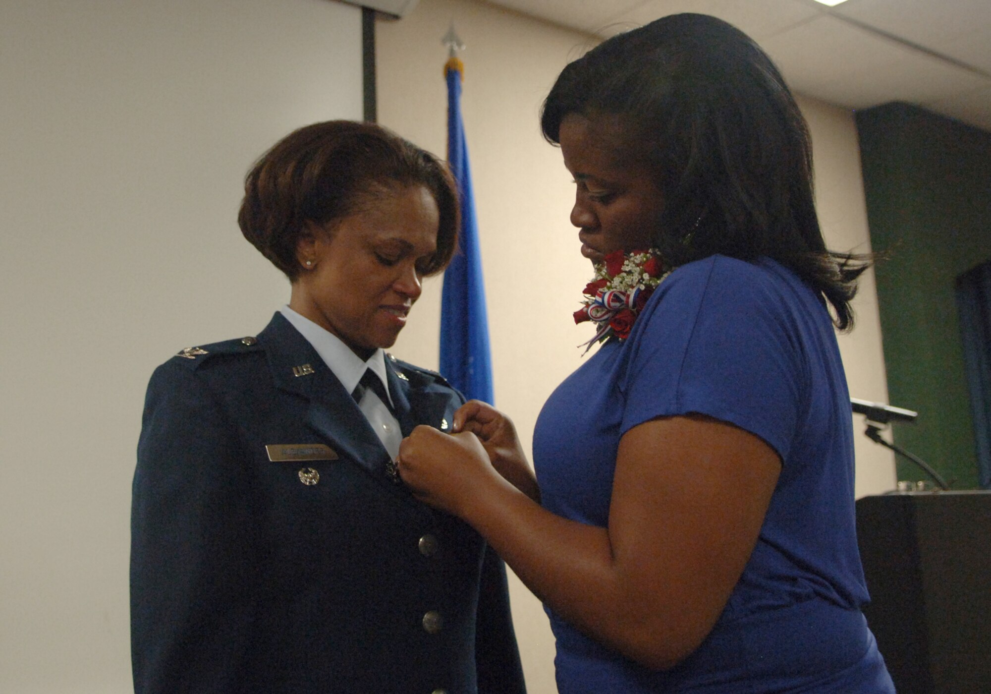 ELLSWORTH AIR FORCE BASE, S.D. -- Renise Alexander (right), daughter of Col. Renita Alexander, former 28th Mission Support Group commander, pins the colonel’s retirement pin here, Aug. 4. While stationed at Ellsworth, Colonel Alexander was responsible for seven different squadrons involving nearly 8,000 military and civilian members and their families. (U.S. Air Force photo/Senior Airman Kasey Zickmund)