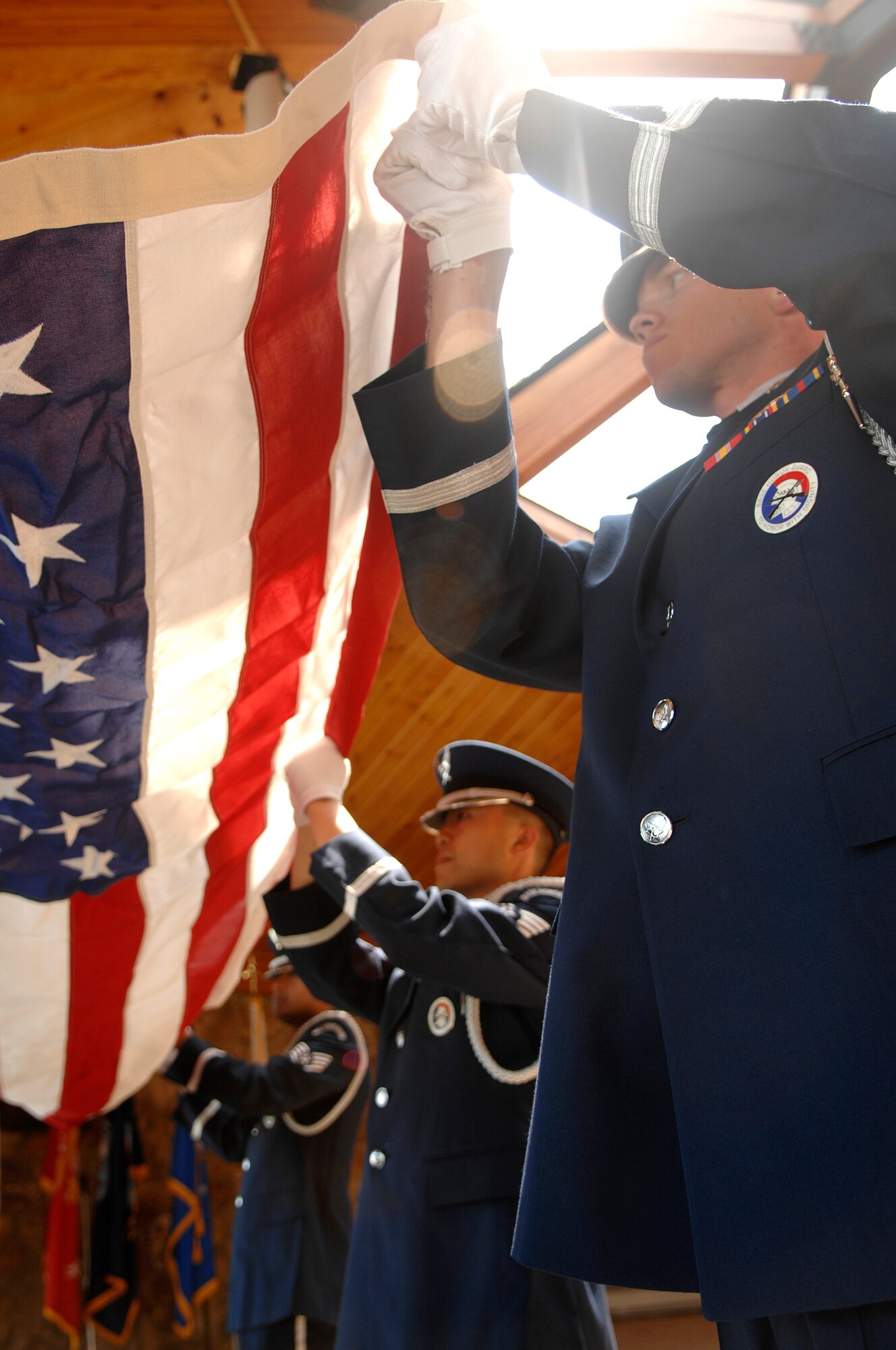 (From right) Airman 1st Class Ray Wahl, Staff Sgt. Daniel Chin and Staff Sgt. Ruben TrejoSanchez, Ellsworth Air Force Base Honor Guard members, fold a flag before a funeral service held at the Black Hills National Cemetery, July 31. The service was held for a retired Air Force master sergeant. (U.S. Air Force photo/Senior Airman Marc I. Lane)(Released)
