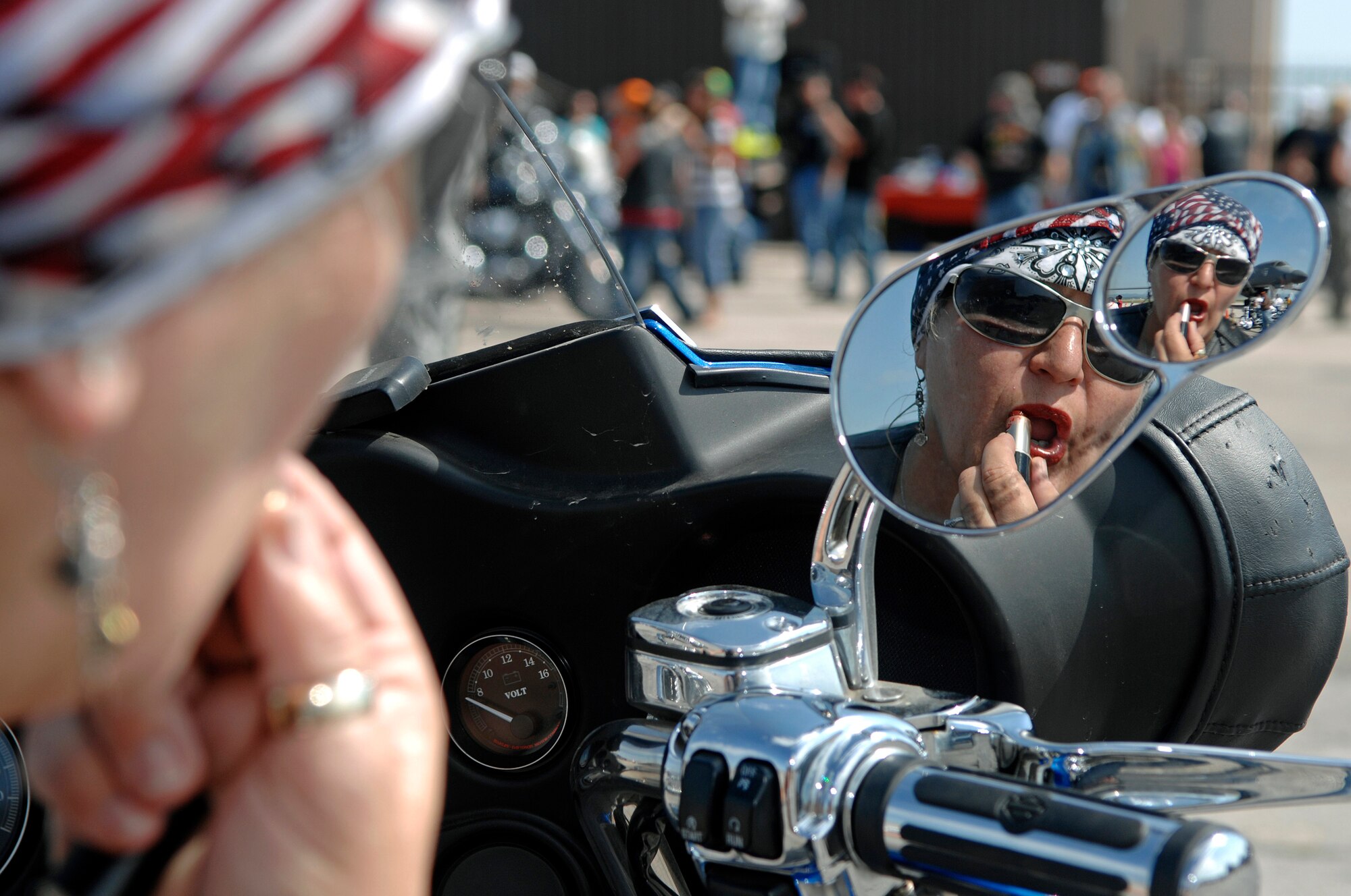 Koni Dearman, a three-year Sturgis rally veteran from Armos, Calif., applies lipstick while sitting on her motorcycle on the flight, August 5. Ms Dearman is one of approximately 450 riders that met on Ellsworth before participating in the Dakota Thunder Motorcycle Run to the 68th Annual Sturgis Motorcycle Rally. (U.S. Air Force photo/Senior Airman Marc I. Lane)
