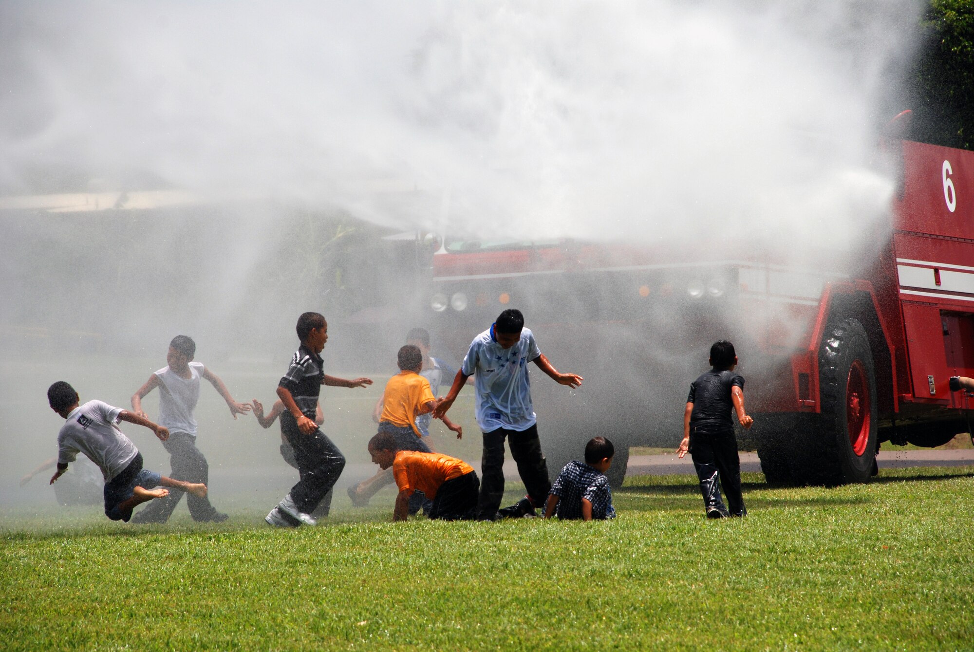 Boys from the Hogar de Ninos Nazareth Orphanage in Comayagua, Honduras, play in the water spray from a Joint Task Force-Bravo fire truck. More than 50 boys from the orphanage came to Soto Cano Air Base Aug. 2 for a day of fun and activities.