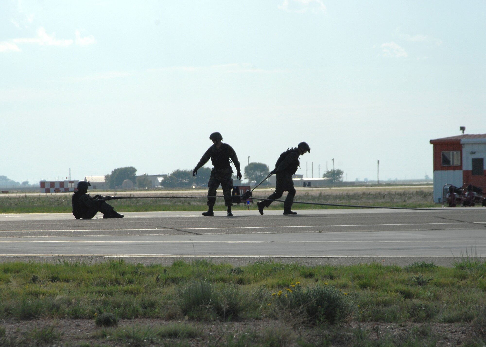 CANNON AIR FORCE BASE, N.M. -- Tech. Sgt. Brent Wiggett, 27th Special Operations Logistics Readiness Squadron, uses a squeegee to return fuel to the tanker aircraft after refueling the reciever aircraft. Tech. Sgt. Joshua Creegar, 27 SOLRS, anchors the hose to provide resistance so that Sergeant Wiggett can pull the squeegee. (U.S. Air Force phto by Airman Maynelinne De La Cruz)