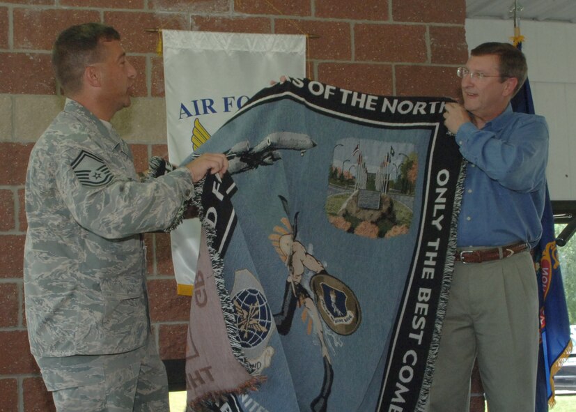 GRAND FORKS AIR FORCE BASE, N.D. – Sen. Kent Conrad (N.D) accepts a throw blanket depicting the Warriors of the North from Senior Master Sgt. Daniel Becker, Red River Valley Air Force Association President August 4. Senator Conrad was the guest speaker at Air Force Association Barbecue where he spoke about the proud past and bright future of the base. (U.S. Air Force photo/Senior Airman Tiffany Colburn)