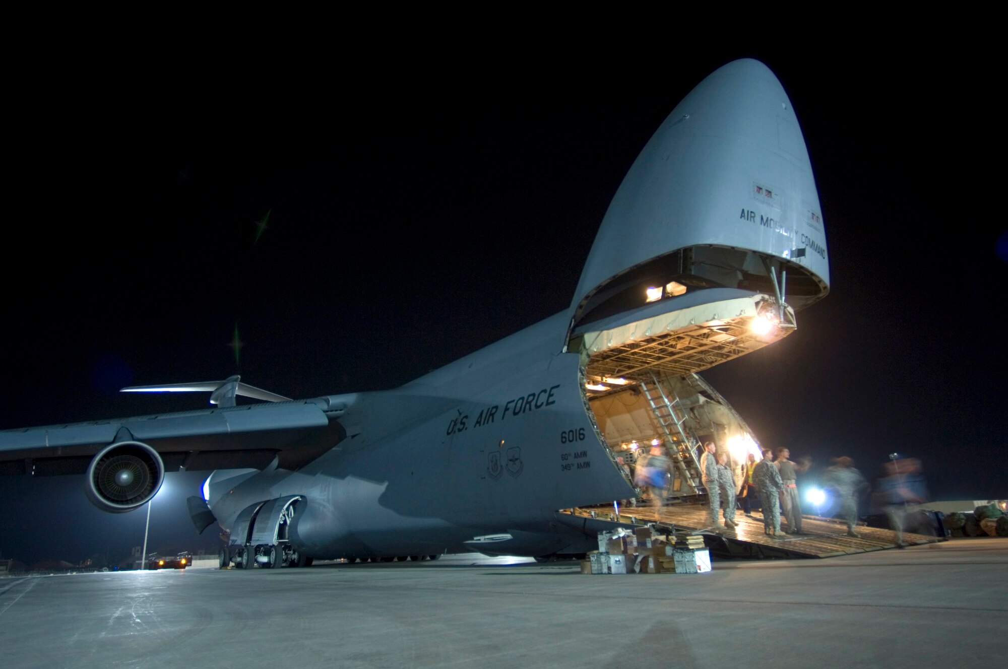 Airmen unload a C-5 Galaxy carrying troops, supplies and vehicles Aug. 3 at Joint Base Balad, Iraq.  More than 950 cargo aircraft, 12,000 tons of cargo and 19,000 passengers are processed each month, making it the busiest aerial port operation in the Department of Defense. This C-5 is deployed from the 22nd Airlift Squadron at Travis Air Force Base, Calif. (U.S. Air Force photo/Airman 1st Class Jason Epley) 