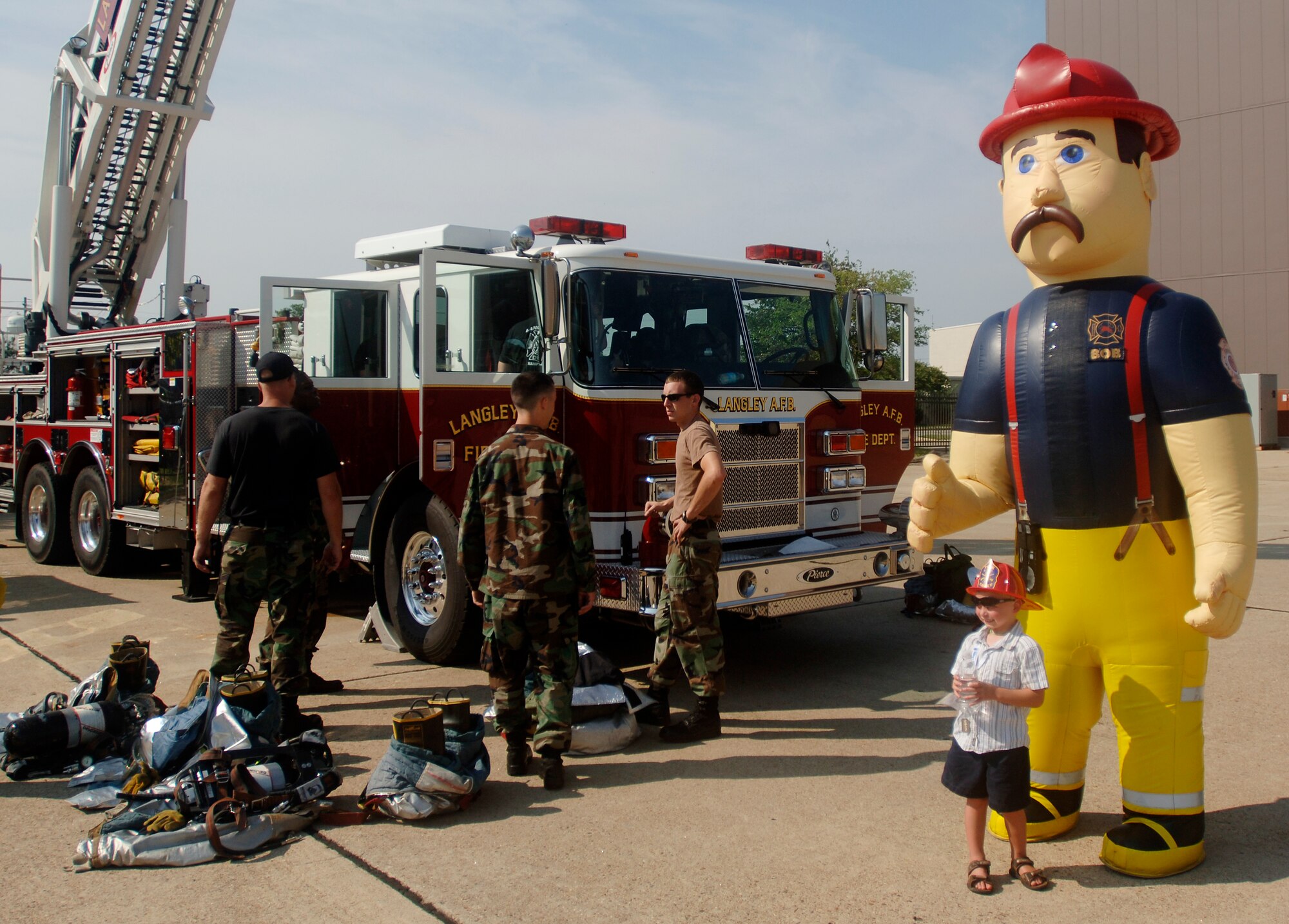 LANGLEY AIR FORCE BASE, Va. -- Fire fighters from the 1st Civil Engineering Squadron provide demonstrations for children at the Operation Hero event here on Aug. 24.  Operation Hero is a program to educate military children about deployments.  (U.S. Air Force photo/Tech. Sgt. Levi Collins)  