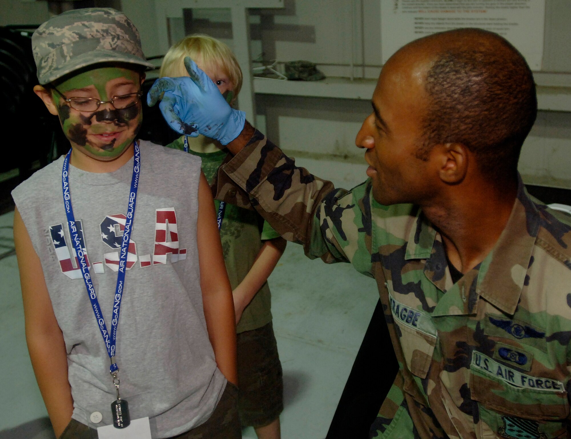 LANGLEY AIR FORCE BASE, Va. -- Staff Sgt. Tatchy Kragbe, of the 1st Civil Engineering Squadron, paints young Mark Jensen face, son of Capt. Felicia Jensen, Air Combat Command personnelist, at the Operation Hero event here on Aug. 24.  Operation Hero is a program to educate military children about deployments. (U.S. Air Force photo/Tech. Sgt. Levi Collins)  