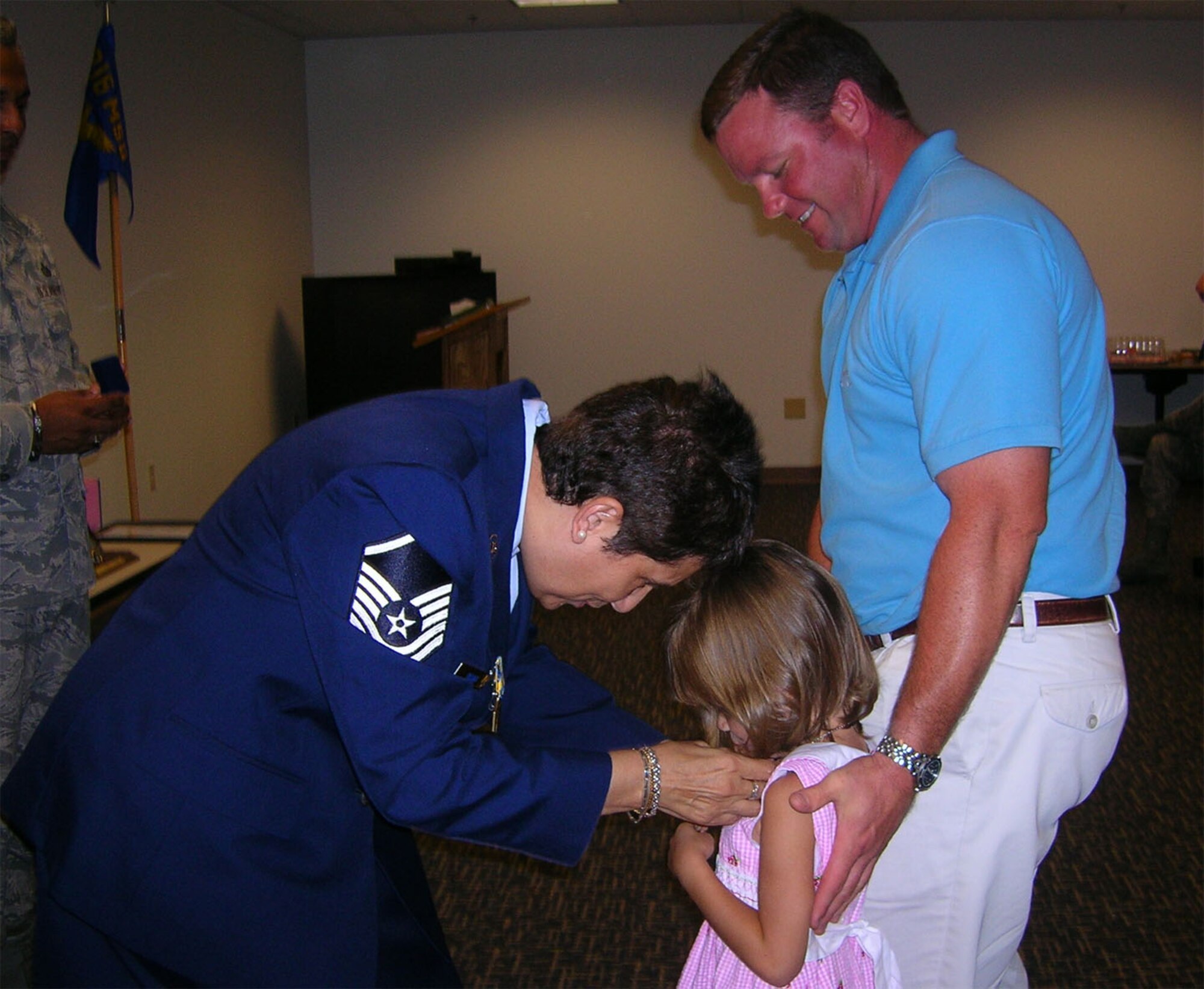 SEYMOUR JOHNSON AIR FORCE BASE, N.C. -- Master Sgt. Alfonsina Okano (left) presents her dog tags to her granddaughter upon her retirement in August. Sgt. Okano was a Reservist with the 916th Mission Support Flight and worked as a group career assistance advisor.