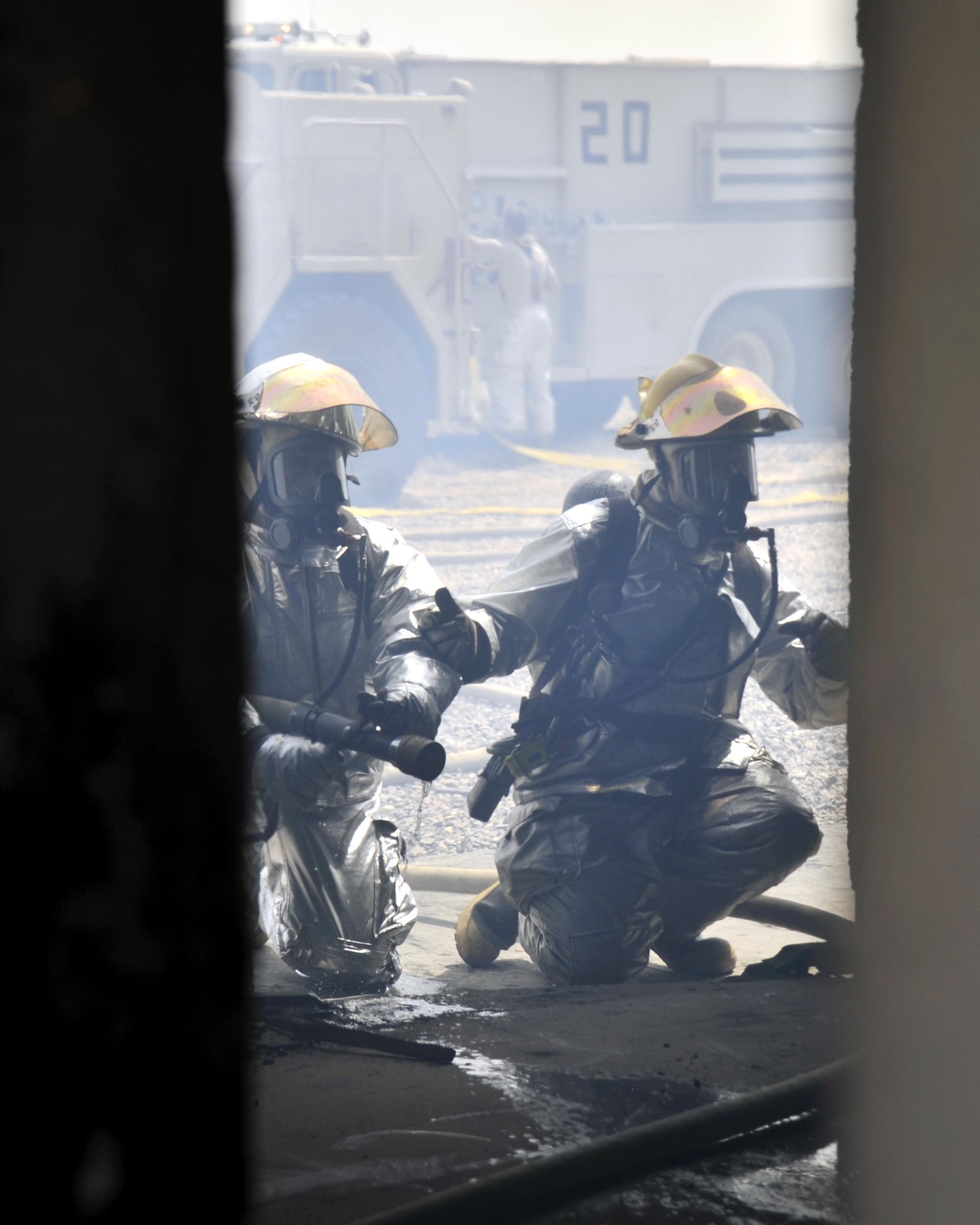 8/5/2008 - BAGHDAD INTERNATIONAL AIRPORT, Iraq -  Airmen from the 447th Expeditionary Civil Engineer Squadron and Iraqi firefighters prepare to enter a burning building during a combined live fire training exercise. (U.S. Air Force Photo by Master Sgt. Brian Davidson)