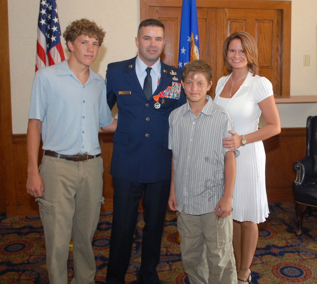The Mays (From left) -- Joseph III, Chief Master Sgt. Joseph May Jr., James and Veronica pause for a family photo after his triple crown ceremony Aug. 1. During the ceremony, Chief May received a triple crown -- he was officially promoted to chief master sergeant and awarded his first Combat Action Medal and second Bronze Star. (U.S. Air Force photo by Rich McFadden)