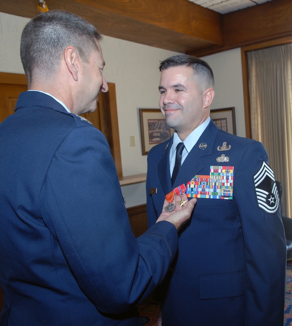 Col. Mark Correll, Air Education and Training Command civil engineer, awards a Bronze Star and Combat Action Medal to Chief Master Sgt. Joseph May Jr., AETC's explosive ordnance disposal functional manager, during a ceremony Aug. 1. During the ceremony, Chief May received a triple crown -- he was officially promoted to chief master sergeant and awarded his first Combat Action Medal and second Bronze Star. (U.S. Air Force photo by Rich McFadden)