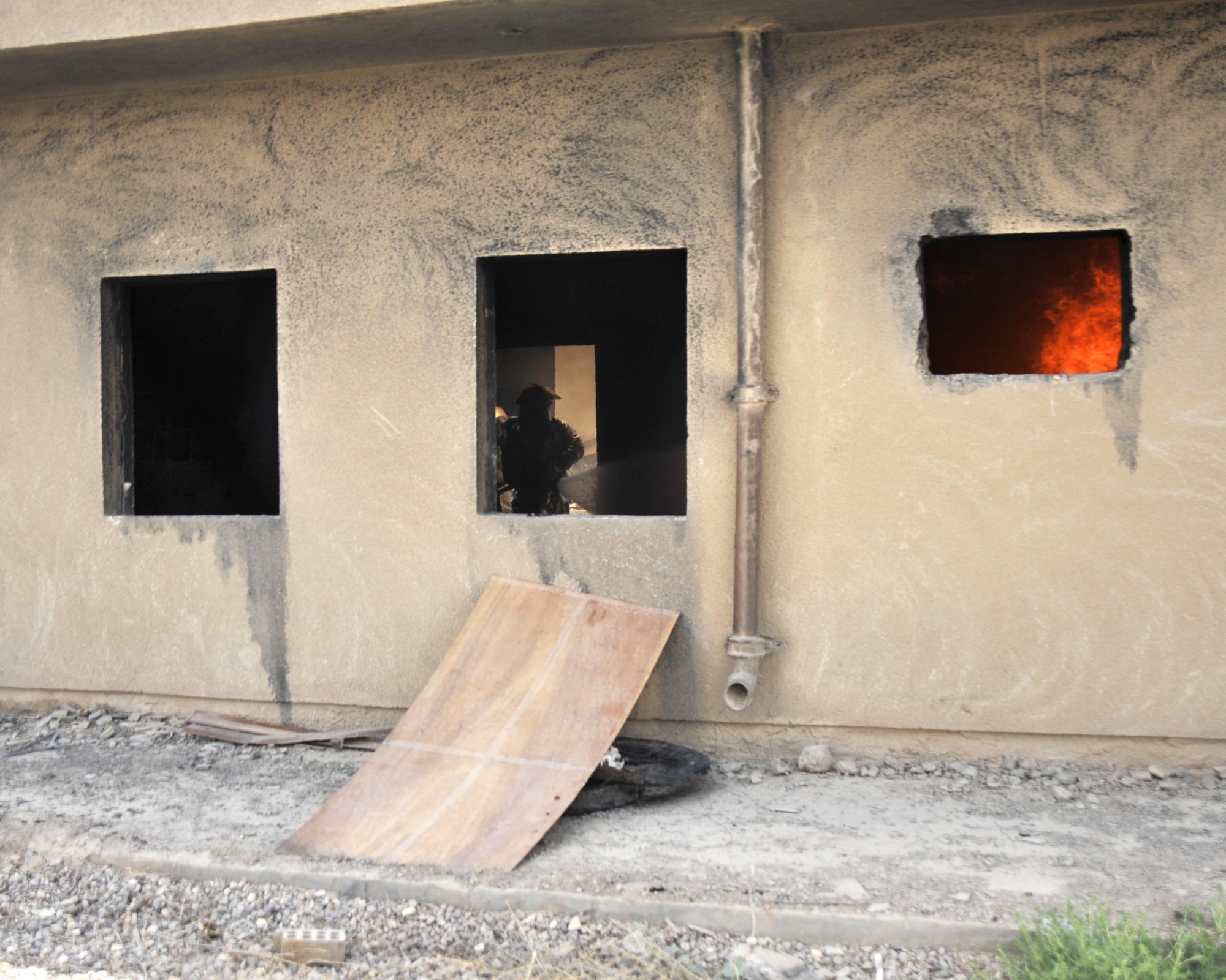 8/5/2008 - BAGHDAD INTERNATIONAL AIRPORT, Iraq -  A firefighter from the 447th Expeditionary Civil Engineer Squadron at Sather Air Base moves in to position during a combined live fire training exercise with Iraqi firefighters. (U.S. Air Force Photo by Master Sgt. Brian Davidson)