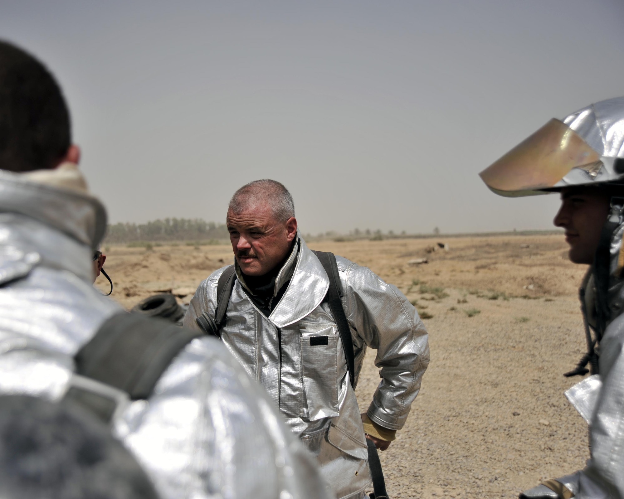 8/5/2008 - BAGHDAD INTERNATIONAL AIRPORT, Iraq -  Tech. Sgt. Don Edgar, 447th Expeditionary Civil Engineer firefighter, talks with fellow American and Iraqi firefighters about their response during a live burn training exercise. Sergeant Edgar is a New York Air National Guard Airman deployed from the 174th Fighter Wing in Syracuse. When he is not wearing his Air Force firefighter uniform, Sergeant Edgar serves as a state corrections officer. (U.S. Air Force Photo by Master Sgt. Brian Davidson)