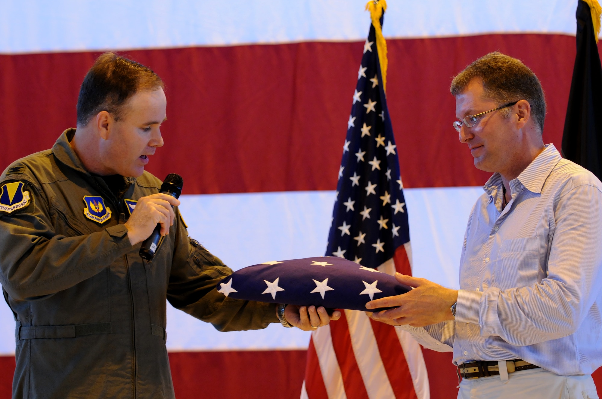 United States Air Force Col. Doug Sevier, 86th Airlift Wing vice commander, left, presents Dave Pelzer with an American flag during the 86th AW Commander's Call Aug. 8, 2008, Ramstein Air Base, Germany. As a Former Air Force air crewmember, Mr. Pelzer played a major role in the mid-air refueling of the once highly secretive SR-71 Blackbird and the F-117 Stealth Fighter, but is best known for his six inspirational books that have been on the best sellers list for over 13 years combined. (U.S. Air Force photo by Airman 1st Class Nathan Lipscomb)(Released)