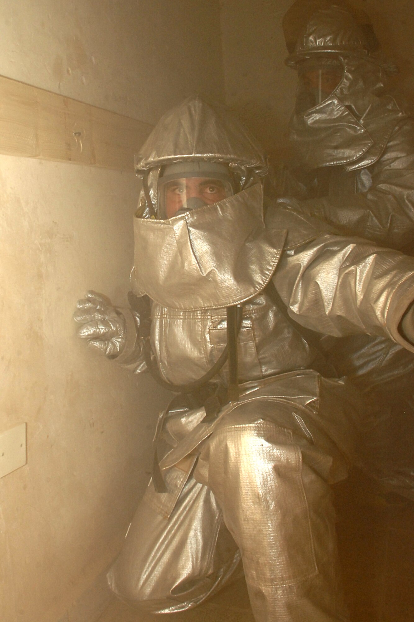 KIRKUK REGIONAL AIR BASE, Iraq -- Iraqi firefighters go through a smoky room during refresher training within confined spaces here July 30.  The 506th Expeditionary Civil Engineer Squadron firefighters conducted the training to teach the Iraqi firefighters what to do when there is a fire with victims trapped inside a building. (U.S. Air Force photo/Senior Airman Randi Flaugh)
