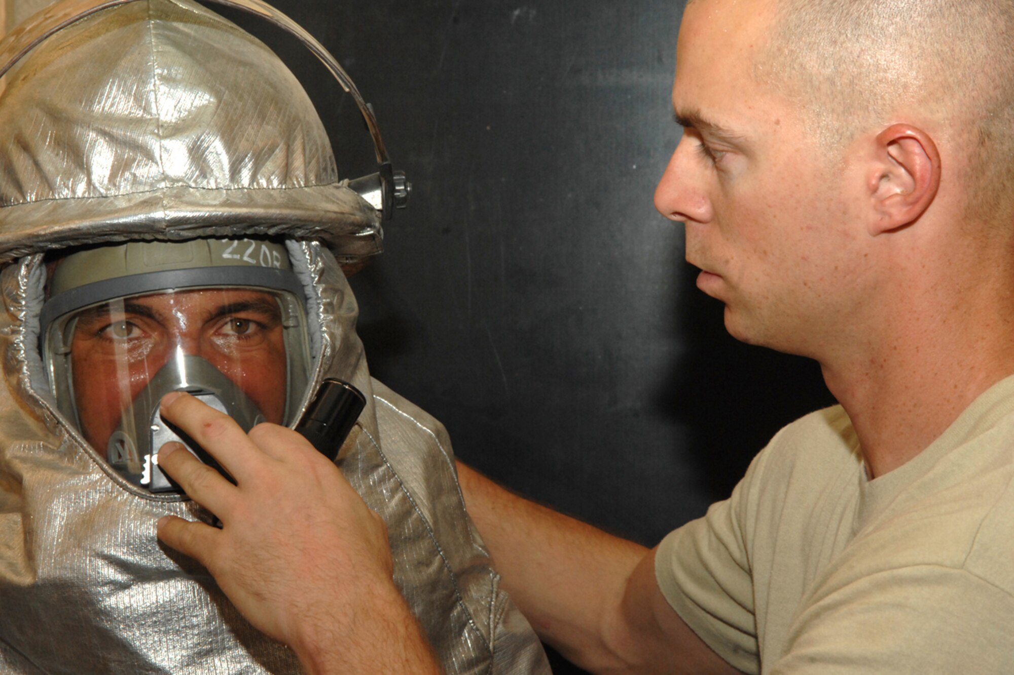 KIRKUK REGIONAL AIR BASE, Iraq -- Staff Sgt. Craig Cusenz, 506th Expeditionary Civil Engineer Squadron firefighter,  ensures an Iraqi firefighter can breathe air from the self contained breathing apparatus bottle after closing his Spiro-Hatch and adjusting the positive pressure switch on his mask here July 30. The 506 ECES firefighters conducted the training to teach the Iraqi firefighters what to do when there is a fire with victims trapped inside a building.  Sergeant Cusenz is deployed from Tinker Air Force Base, Okla., and calls Fort Worth, Texas, home. (U.S. Air Force photo/Senior Airman Randi Flaugh)