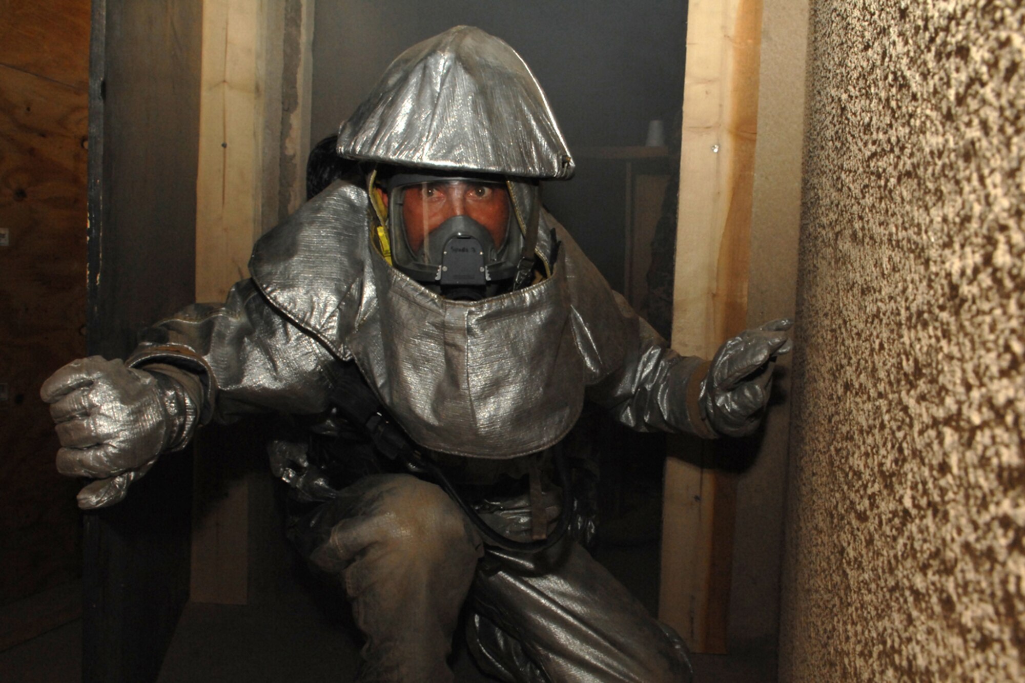 KIRKUK REGIONAL AIR BASE, Iraq – An Iraqi firefighter comes out of a smoky room during refresher training within confined spaces here July 30.  The 506th Expeditionary Civil Engineer Squadron firefighters conducted the training to teach the Iraqi firefighters what to do when there is a fire with victims trapped inside a building. (U.S. Air Force photo/Senior Airman Randi Flaugh) 
