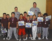 MINOT AIR FORCE BASE, N.D. -- The American Eagles (team 8) and their coaches, Airman 1st Class Benjamin Stratton, 5th Bomb Wing Public Affairs staff writer, and Eryn Mertins, daughter of Master Sgt. Byron Mertins, 5th Operations Support Squadron aviation resource functional manager, pose for a photograph at their end of season party at Darbyland in the Rough Riders Center July 31 here. The kids participated in the summer youth baseball program at the David C. Jones Youth Center. Baseball is one way Minot AFB kids stay busy during the summer months. It is also a great opportunity for parents to encourage their kids to participate in outdoor activities and stay active. (Courtesy photo)