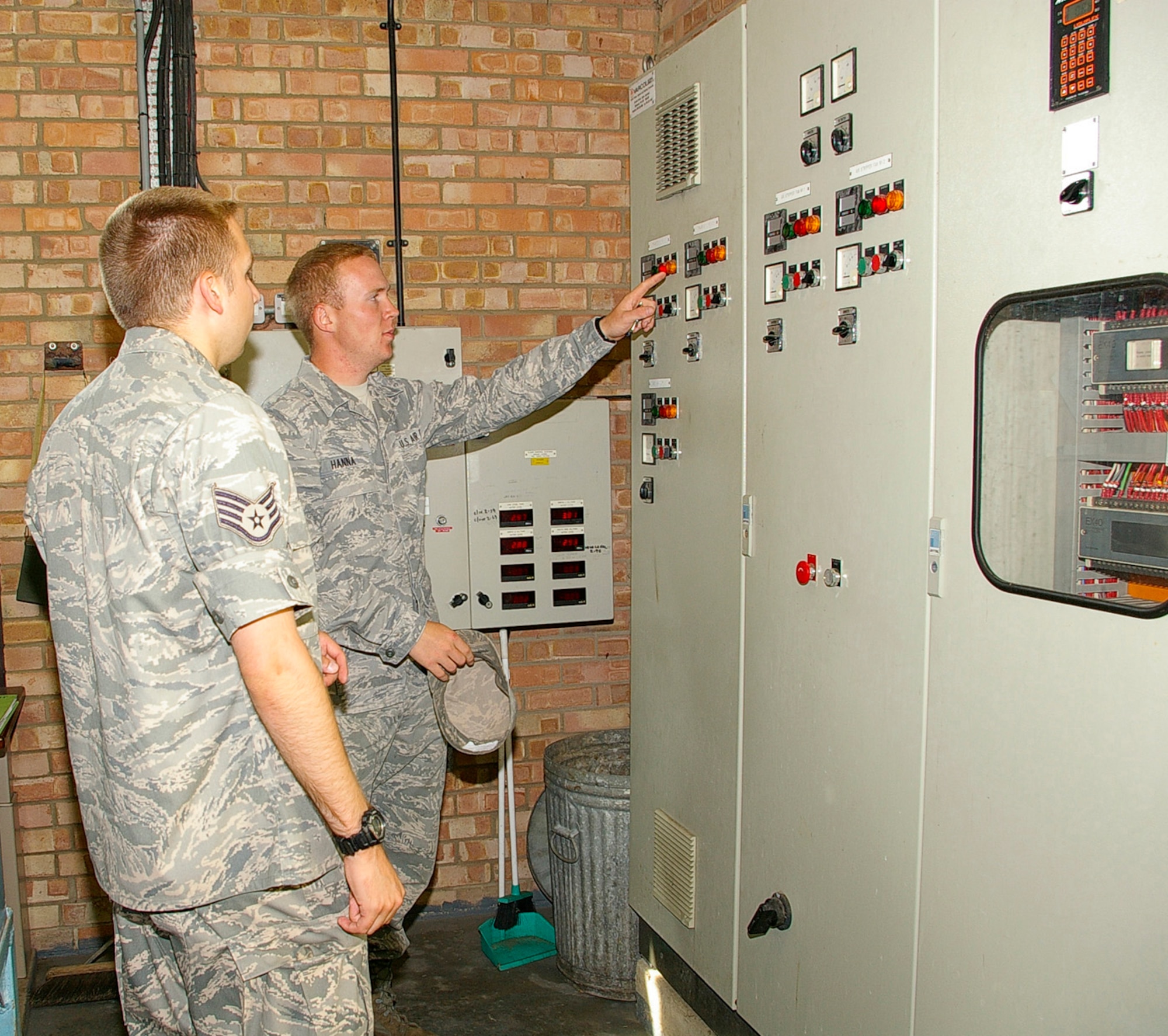 Airman James Hanna, 100th CES Utilities Flight, shows Staff Sgt. Adam Grosek, 352nd Operations Support Squadron Bionvironmental Engineering, an ESOHCAMP assessor, pump controls at the drinking water treatment facility on RAF Mildenhall. Water quality was one of the environmental protocols assessed during the ESOHCAMP. (U.S. Air Force photo by Karen Abeyasekere)