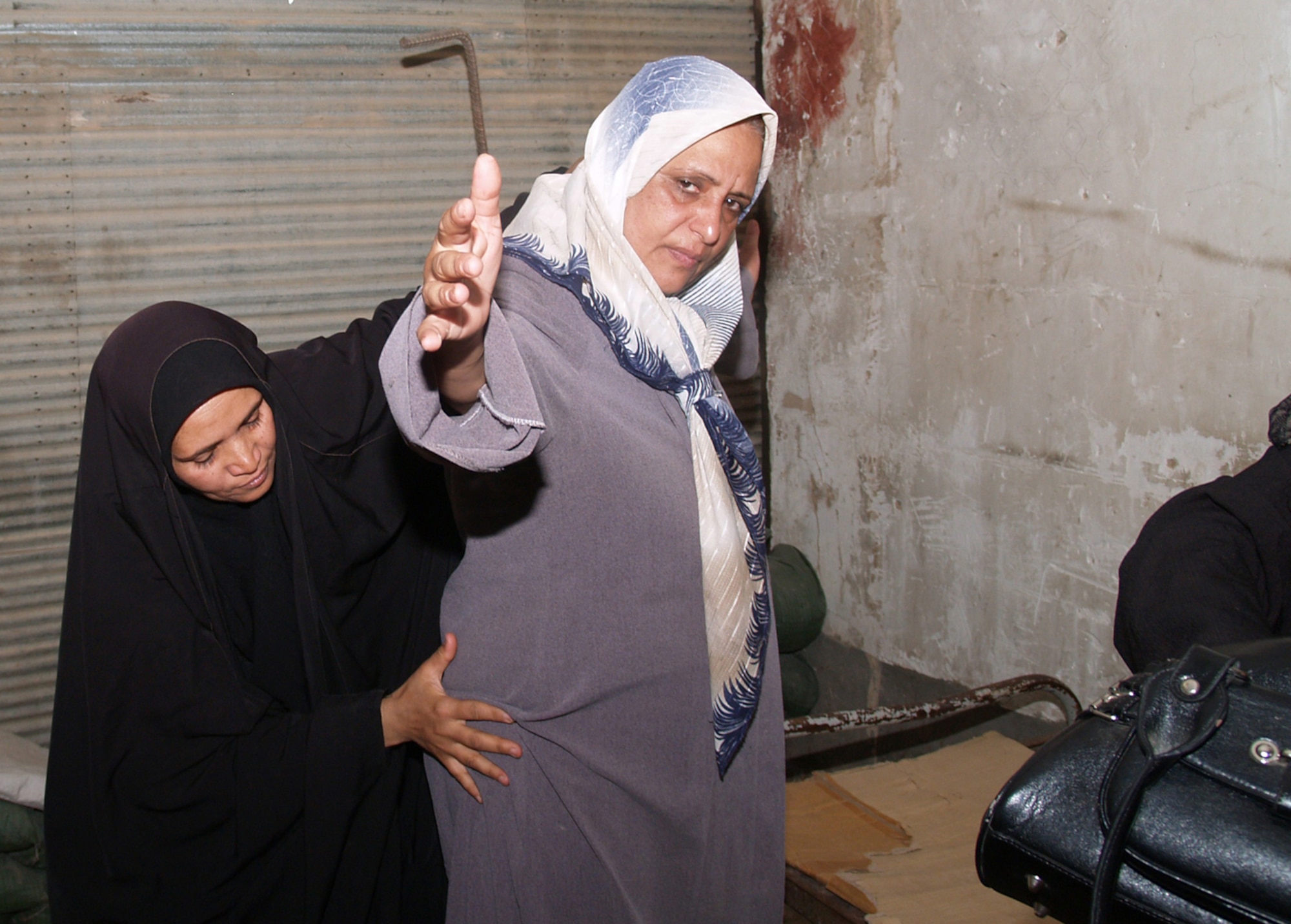 BALAD CITY, Iraq -- Fatma Mohammed Abdulrassol checks an Iraq female at a checkpoint in Balad, Iraq, July 24. The Army's 164th Military Police Company has trained Ms. Abdulrassol and other Iraqi women to conduct searches at checkpoints in Balad City. (U.S. Army photo/Pfc. Amanda Tucker)