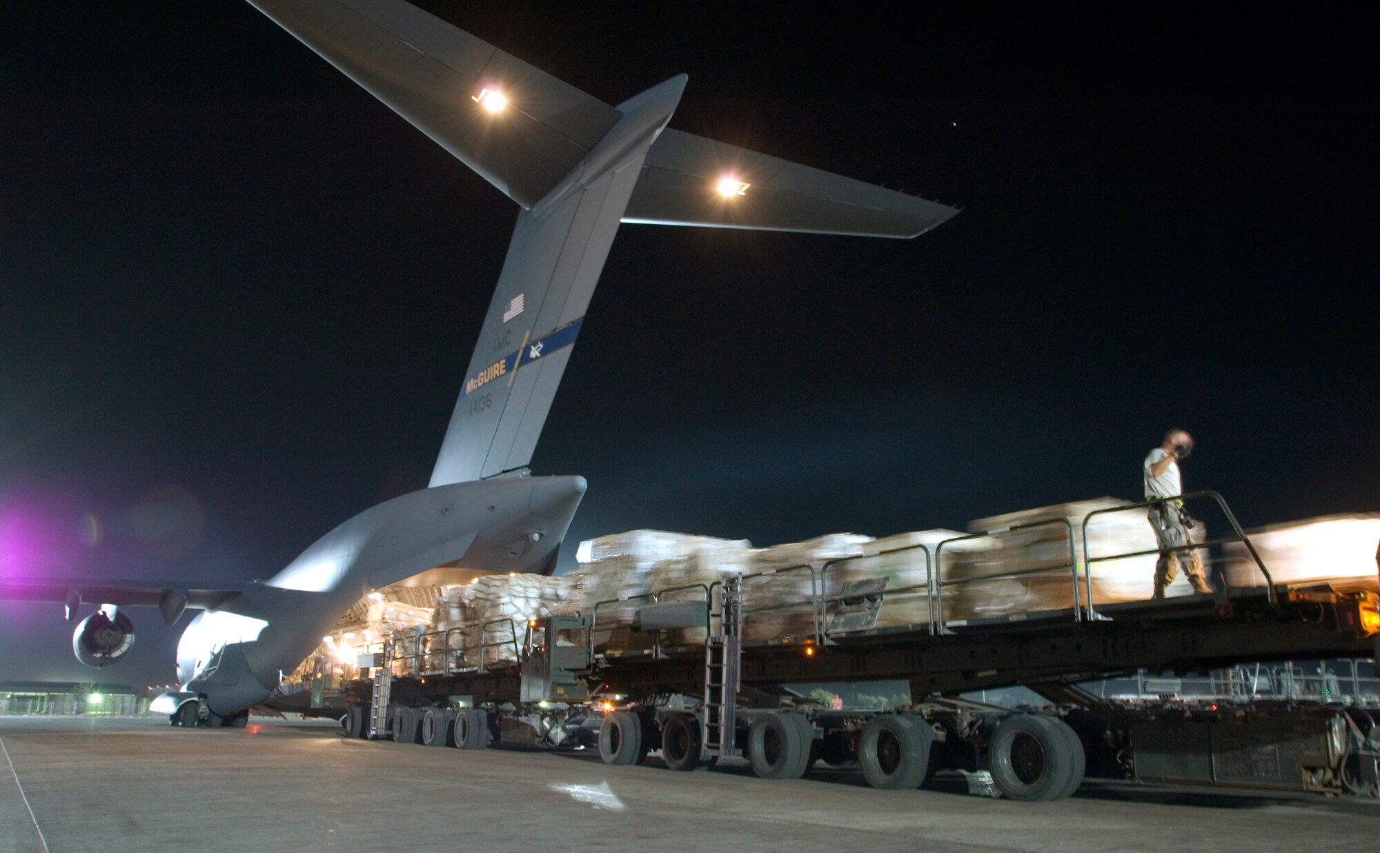 JOINT BASE BALAD, Iraq -- A C-17 Globemaster crew loads more than 56,000 pounds of cargo from three Tunner 60K Loaders here Aug. 3. Joint Base Balad processes more than 950 cargo aircraft, 12,000 tons of cargo and 19,000 passengers per month, making it the busiest aerial port operation in the Department of Defense. The C-17 is deployed from the 305th Air Mobility Wing at McGuire Air Force Base, N.J. (U.S. Air Force photo/Airman 1st Class Jason Epley)