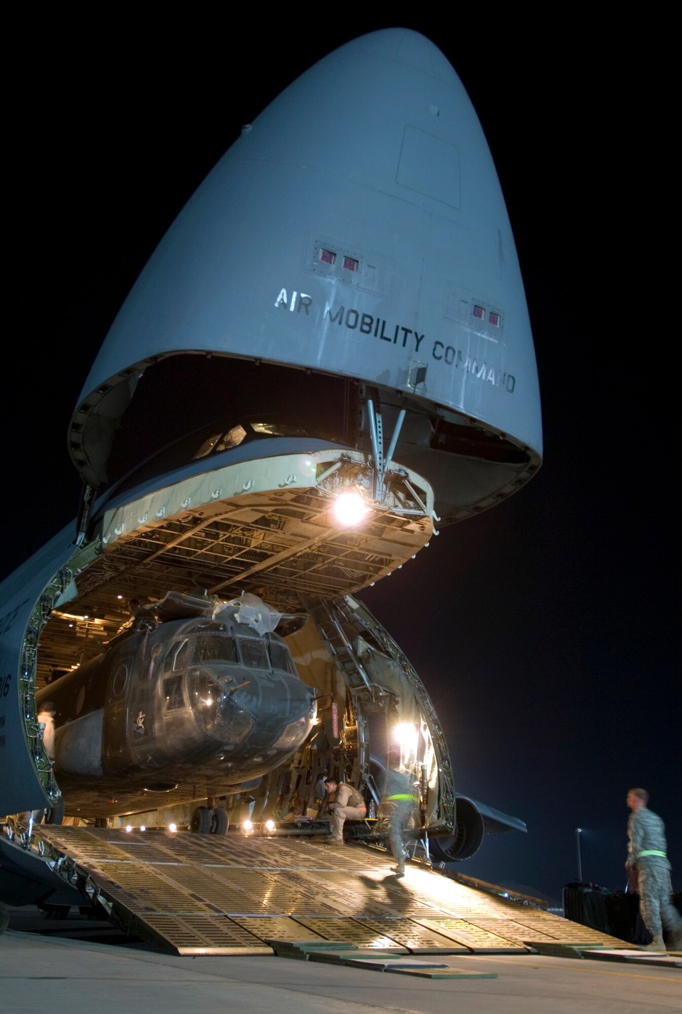 JOINT BASE BALAD, Iraq -- A C-5 Galaxy crew loads a CH-47D Chinook heavy lift helicopter into its cargo bay here Aug. 3. Joint Base Balad processes more than 950 cargo aircraft, 12,000 tons of cargo and 19,000 passengers per month, making it the busiest aerial port operation in the Department of Defense. The C-5 is deployed from the 22nd Airlift Squadron at Travis Air Force Base, Calif. The Chinook belongs to the Army's Bravo Company, 1st Battalion, 52nd Aviation Regiment, which is deployed to Al Toqaddum, Iraq. (U.S. Air Force photo/Airman 1st Class Jason Epley)