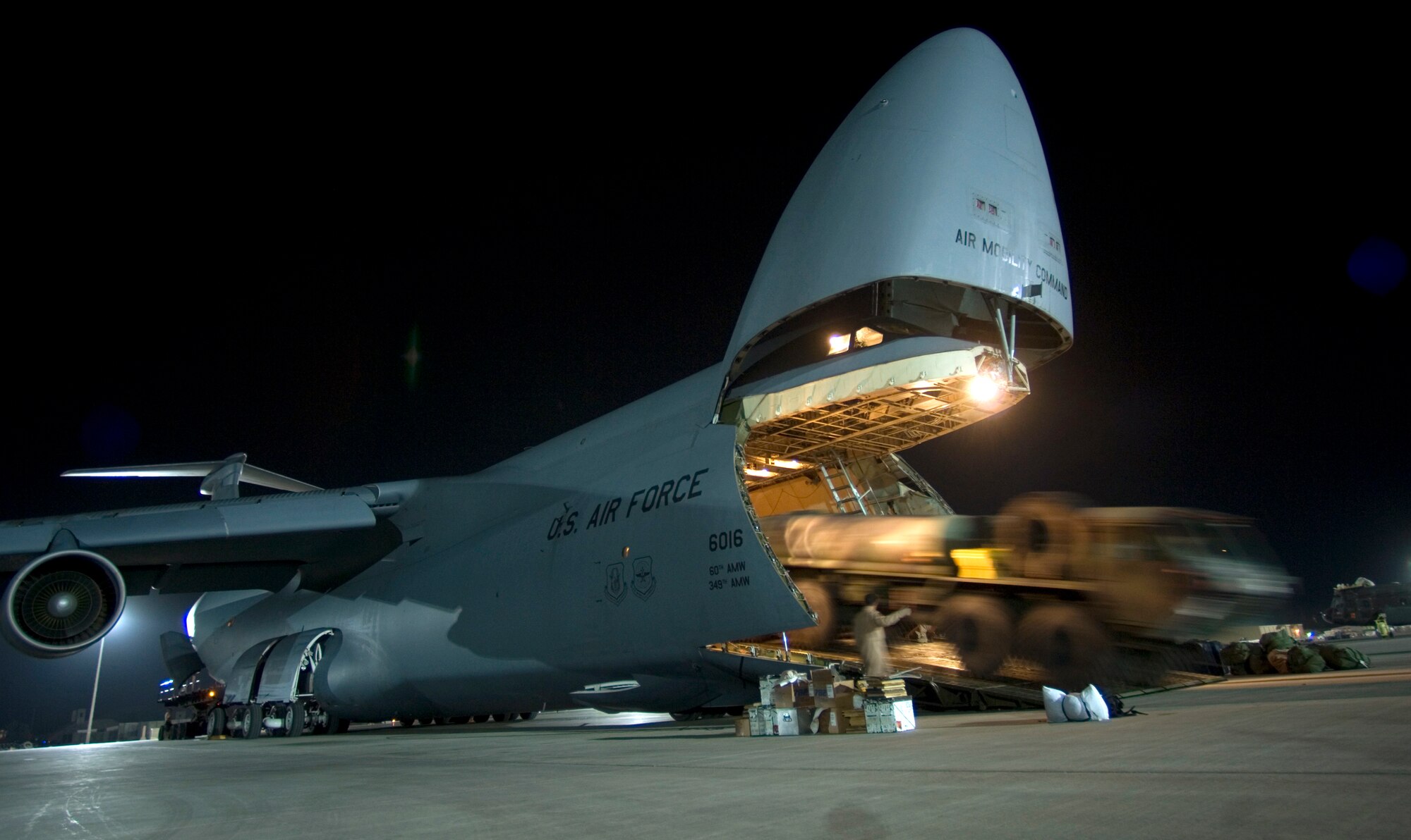 JOINT BASE BALAD, Iraq -- A C-5 Galaxy crew unloads an M-978 Heavy Expanded Mobile Tactical Truck, or HEMTT, here Aug. 3. Joint Base Balad processes more than 950 cargo aircraft, 12,000 tons of cargo and 19,000 passengers per month, making it the busiest aerial port operation in the Department of Defense. The C-5 is deployed from the 22nd Airlift Squadron at Travis Air Force Base, Calif. (U.S. Air Force photo/Airman 1st Class Jason Epley)
