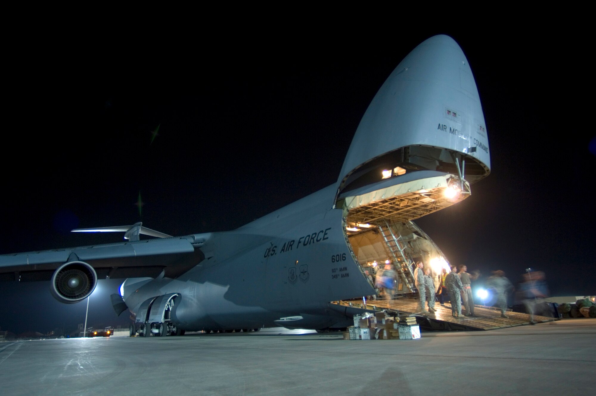 JOINT BASE BALAD, Iraq -- Airmen unload a C-5 Galaxy carrying troops, supplies and vehicles here Aug. 3. Joint Base Balad processes more than 950 cargo aircraft, 12,000 tons of cargo and 19,000 passengers per month, making it the busiest aerial port operation in the Department of Defense. The C-5 is deployed from the 22nd Airlift Squadron at Travis Air Force Base, Calif. (U.S. Air Force photo/Airman 1st Class Jason Epley)