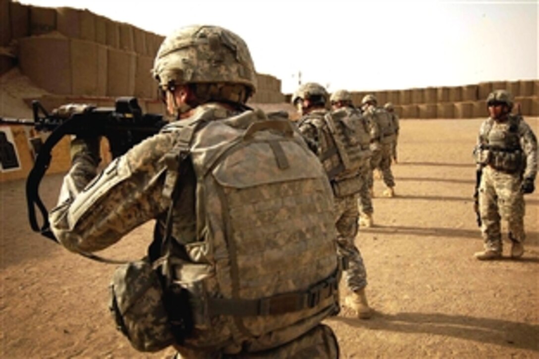 U.S. Army Staff Sgt. Conrad Vasquez, far right, gives commands to soldiers on the firing line of a weapons qualification range on Camp Taji, Iraq, Aug. 3, 2008. The soldiers are assigned to the 2nd Squadron, 14th Cavalry Regiment, 25th Infantry Division.
                       
