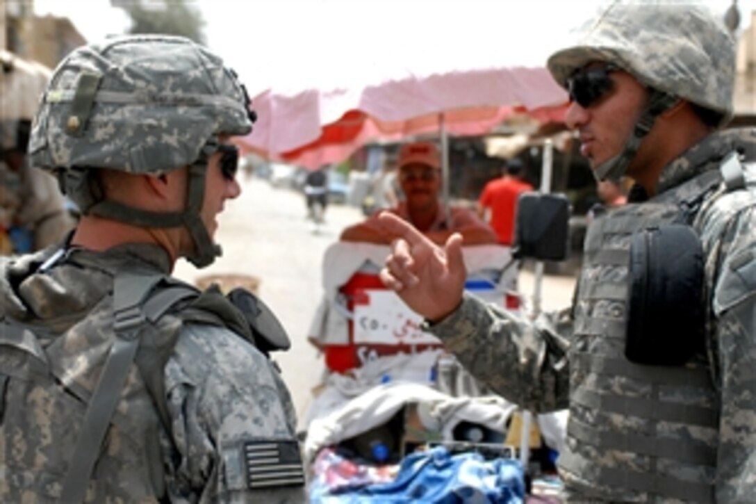U.S. Army Command Sgt. Maj. Daniel Dailey speaks to his interpreter while touring Adhamiyah's fish market in northern Baghdad, Aug. 5, 2008. Dailey is assigned to the 3rd Brigade Combat Team, 4th Infantry Division. 

