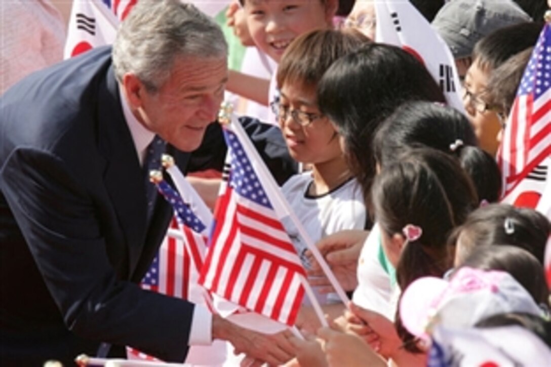President George W. Bush pauses to greet school children, Aug. 6, 2008, during arrival ceremonies at the Blue House, the residence of President Myung-bak Lee of the Republic of Korea, in Seoul. 