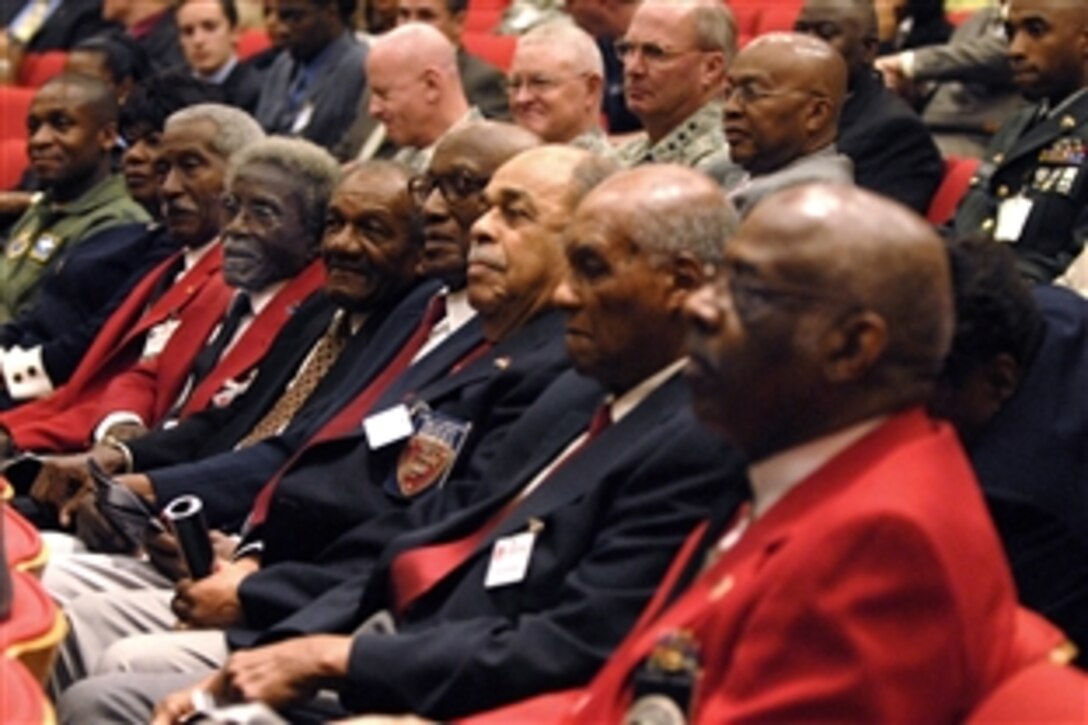 Three members of the Tuskegee Airmen, wearing their signature red jackets, listen as Defense Secretary Robert M. Gates speaks during a ceremony commemorating the 60th anniversary of the signing of Executive Orders 9980 and 9981, which integrated the armed forces and the federal civil service. 