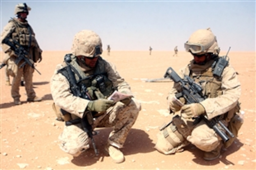 U.S. Marine Staff Sgt. James M. Letsky, center, and Staff Sgt. Justin M. Cuomo, right, plot a search plan during a patrol through the city of Um Al Wazz, Iraq, Aug. 2, 2008. They are assigned to the 4th Light Armored Reconnaissance Battalion, Regimental Combat Team 5. During the operation, the Marines detained an oil smuggler and four oil trucks.
