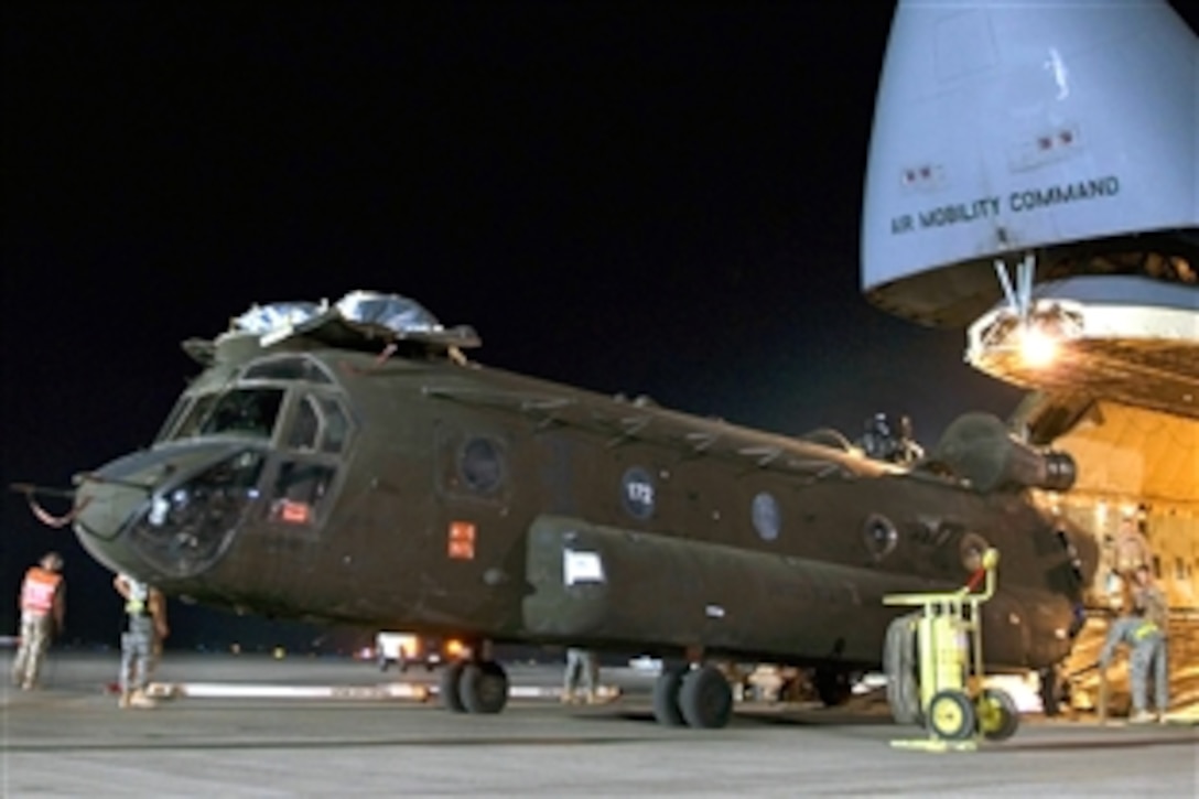 U.S. Air Force airmen load a Chinook heavy-lift helicopter into the cargo bay of a C-5 Galaxy on Joint Base Balad, Iraq, Aug 3. 2008. Military personnel process more than 950 cargo aircraft, 12,000 tons of cargo and 19,000 passengers each month, making it the busiest aerial port operation in the Department of Defense. 