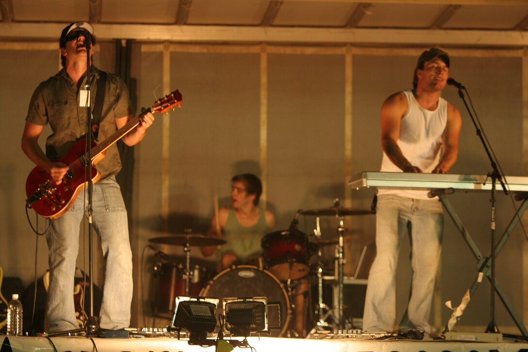 AT-TAQADDUM, Iraq (August 9, 2008) – Catchpenny rocks Camp Taqaddum during a free concert for the troops, Aug. 9. During a break from the pop-rock show, the band spoke with service members and handed out compact discs. Catchpenny will perform 14 shows during their 20-day tour of the Middle East. The five-member band will entertain deployed United States troops in Kuwait, Iraq and United Arab Emirates. “I’m happy to be out here doing something positive for our country,” said Christian Schauf, lead singer of Catchpenny. More than 100 service members and civilians came from all over the base to enjoy the concert.