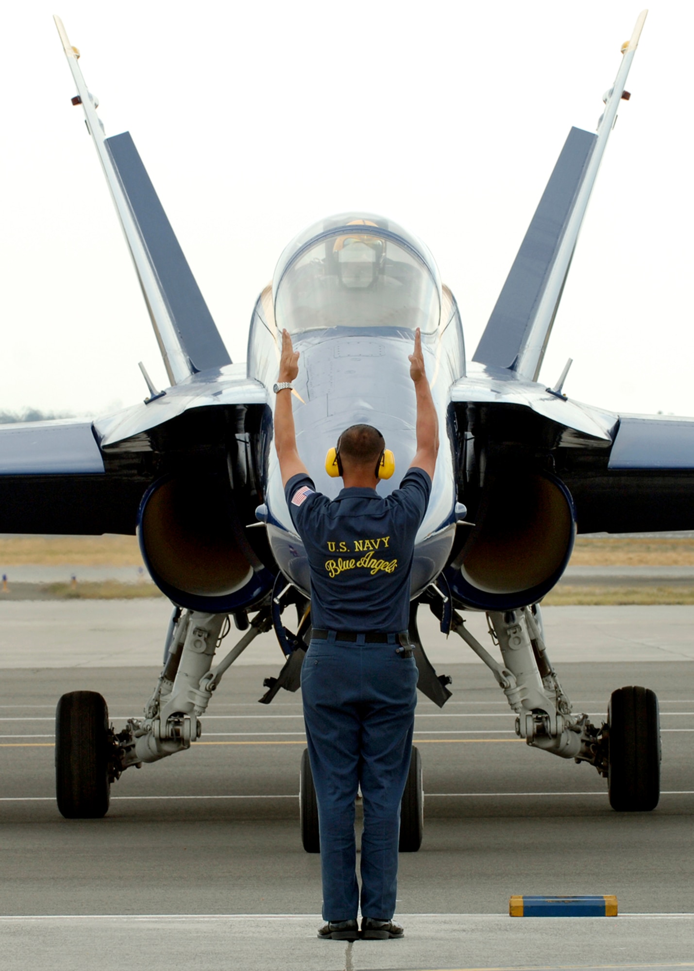 FAIRCHILD AIR FORCE BASE, Wash. – A Navy Blue Angels crew chief recovers one of the Blue Angel F/A 18 Hornets as it arrives at Fairchild from Seattle, Wash., Aug. 7. The Blue Angels will perform aerial acrobatics here Aug. 9 and 10. (U.S. Air Force photo / Airman 1st Class Joshua K. Chapman)
