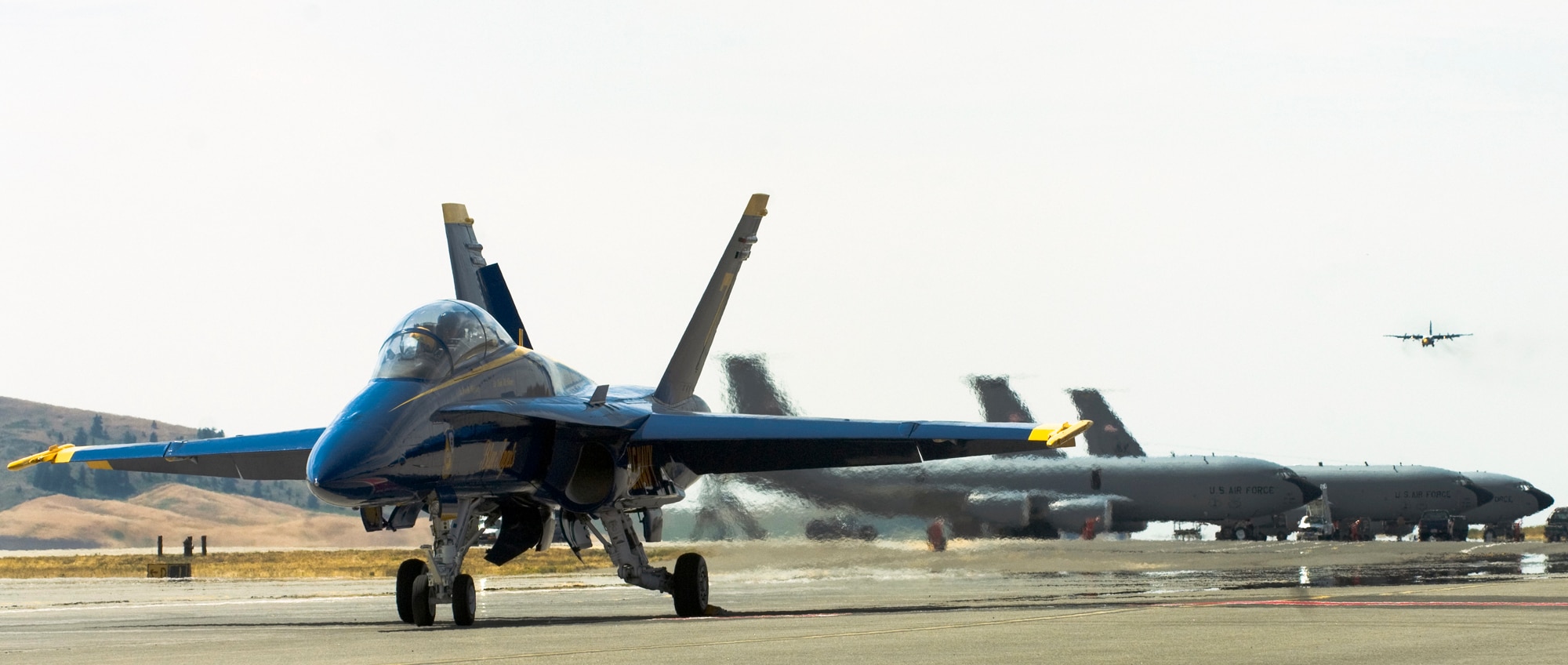 FAIRCHILD AIR FORCE BASE, Wash. – A Navy Blue Angels F/A-18 Hornet prepares to take off from Fairchild airfield while the U.S. Marine Corps “Fat Albert” braces for landing in the distant background. The Navy Blue Angels will be headlining Skyfest 2008, Fairchild’s open house and airshow, Aug. 9 and 10.  (U.S. Air Force photo / Airman 1st Class Joshua K. Chapman)