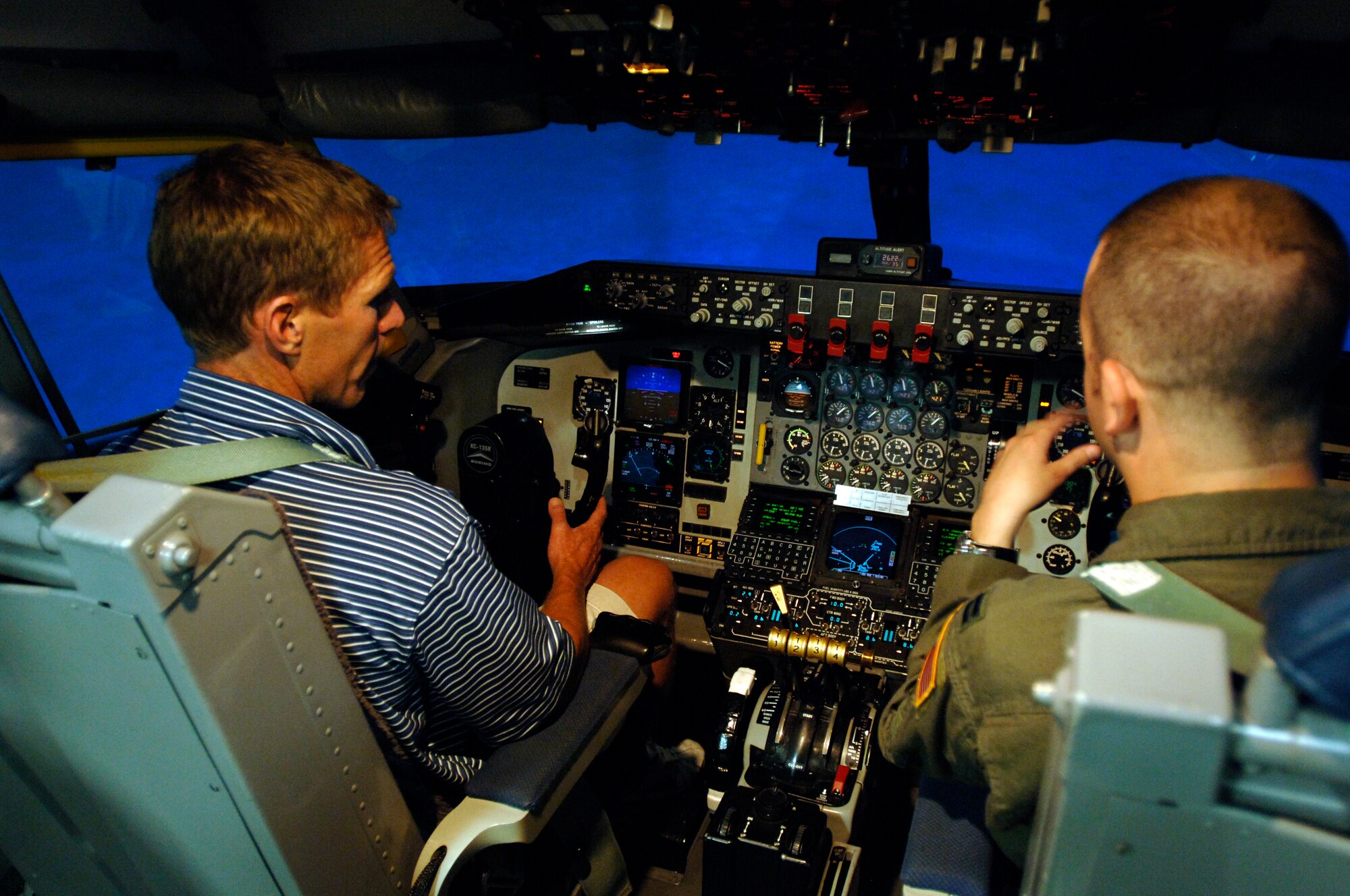 FAIRCHILD AIR FORCE BASE, Wash. -- Capt. Joel Prosio, 92nd Operation Support Squadron, demonstrates to Mark Few, Gonzaga University men’s basketball team head coach, how to fly a KC-135 in a flight simulator here Aug. 6. Mr. Few has served as a coach at Gonzaga University since 1989. (U.S. Air Force photo / Airman 1st Class Melissa Barnett)