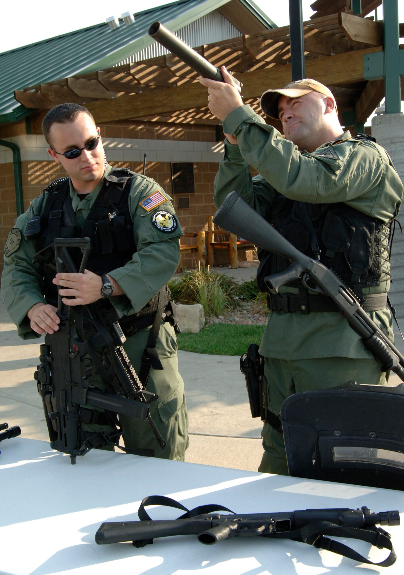 MCCONNELL AIR FORCE BASE, Kan. –- Tech. Sgt. Joe Hardy, 22nd Security Forces Squadron, looks at a 37 milometer gas gun while Staff. Sgt. Wade Waddle, 22nd Security Forces Squadron, stands by during National Night out at Rock River Rapids in Derby, Aug. 5. National Night Out is one way law enforcement agencies and citizens can send a message to criminals that neighborhoods are organized and fighting back. (Photo by Senior Airman Roy Lynch III)