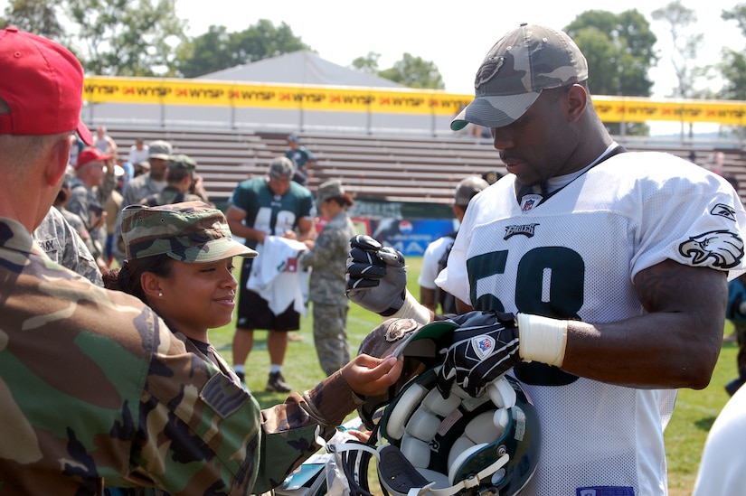 Philadelphia Eagles defensive end Trent Cole signs autographs for Airmen during Military Day at the Eagles training camp Aug. 5, 2008, at Lehigh University in Lehigh, Penn.  More than 200 military members from all the services, including more than 50 Airmen from McGuire Air Force Base and Fort Dix, N.J., attended the event where they were served breakfast and held a meet and greet with Eagles staff and players.  (U.S. Air Force Photo/Tech. Sgt. Scott T. Sturkol)