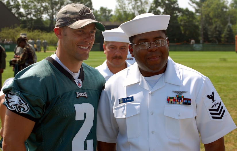 Philadelphia Eagles kicker David Akers stops for a photo with a U.S. Navy sailor during Military Day at the Eagles training camp Aug. 5, 2008, at Lehigh University in Lehigh, Penn.  More than 200 military members from all the services, including more than 50 Airmen from McGuire Air Force Base and Fort Dix, N.J., attended the event where they were served breakfast and held a meet and greet with Eagles staff and players.  (U.S. Air Force Photo/Tech. Sgt. Scott T. Sturkol)